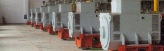 A row of large industrial electrical transformers on a concrete surface