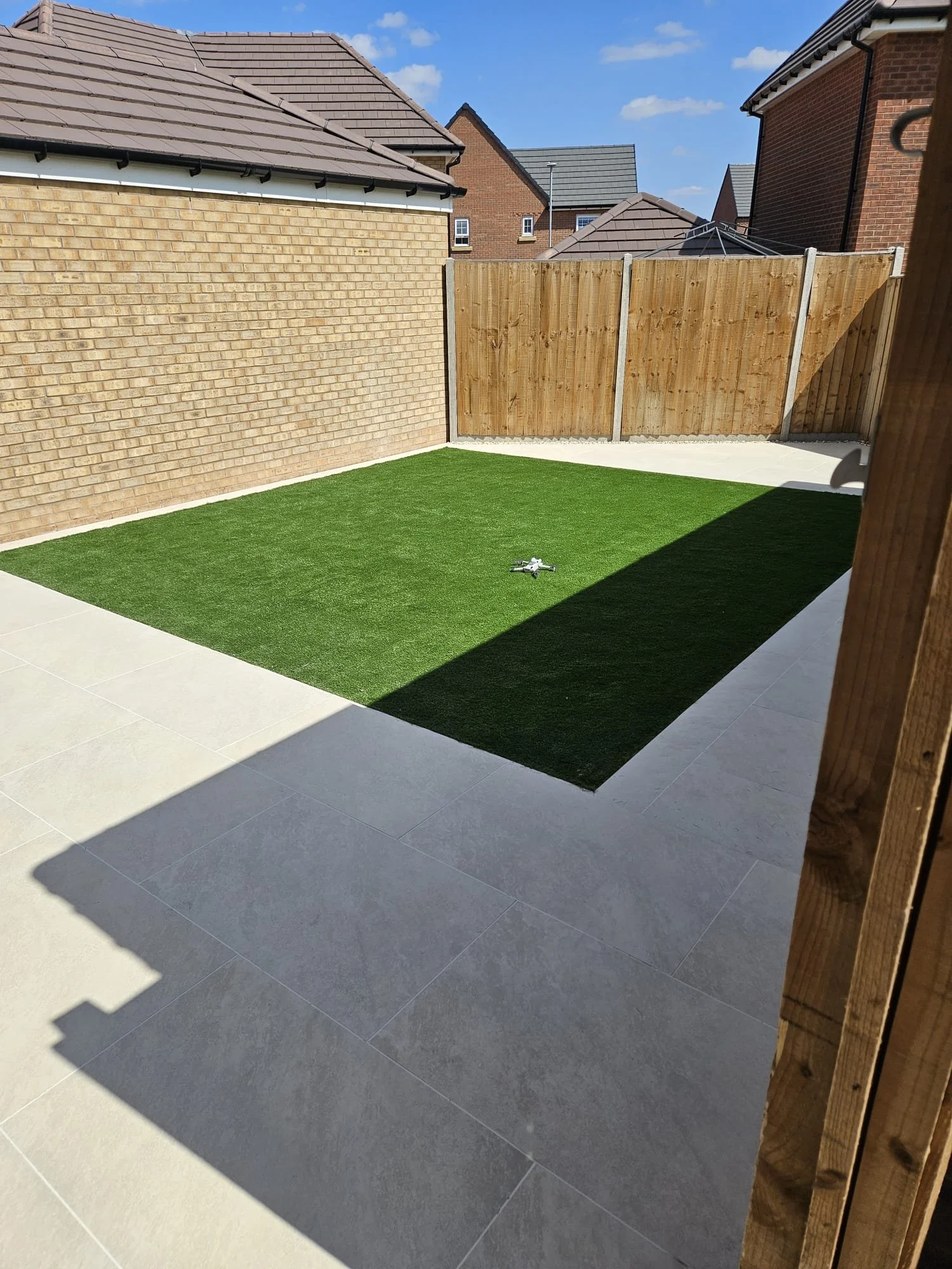 We laid Zaskar Beige Porcelain tiles for a clean, modern finish, installed Hampden Artificial Grass for year-round greenery, and added bullnosed steps for a seamless transition to the home. All expertly grouted using Kerakoll Fugabella - Colour 24 fo
