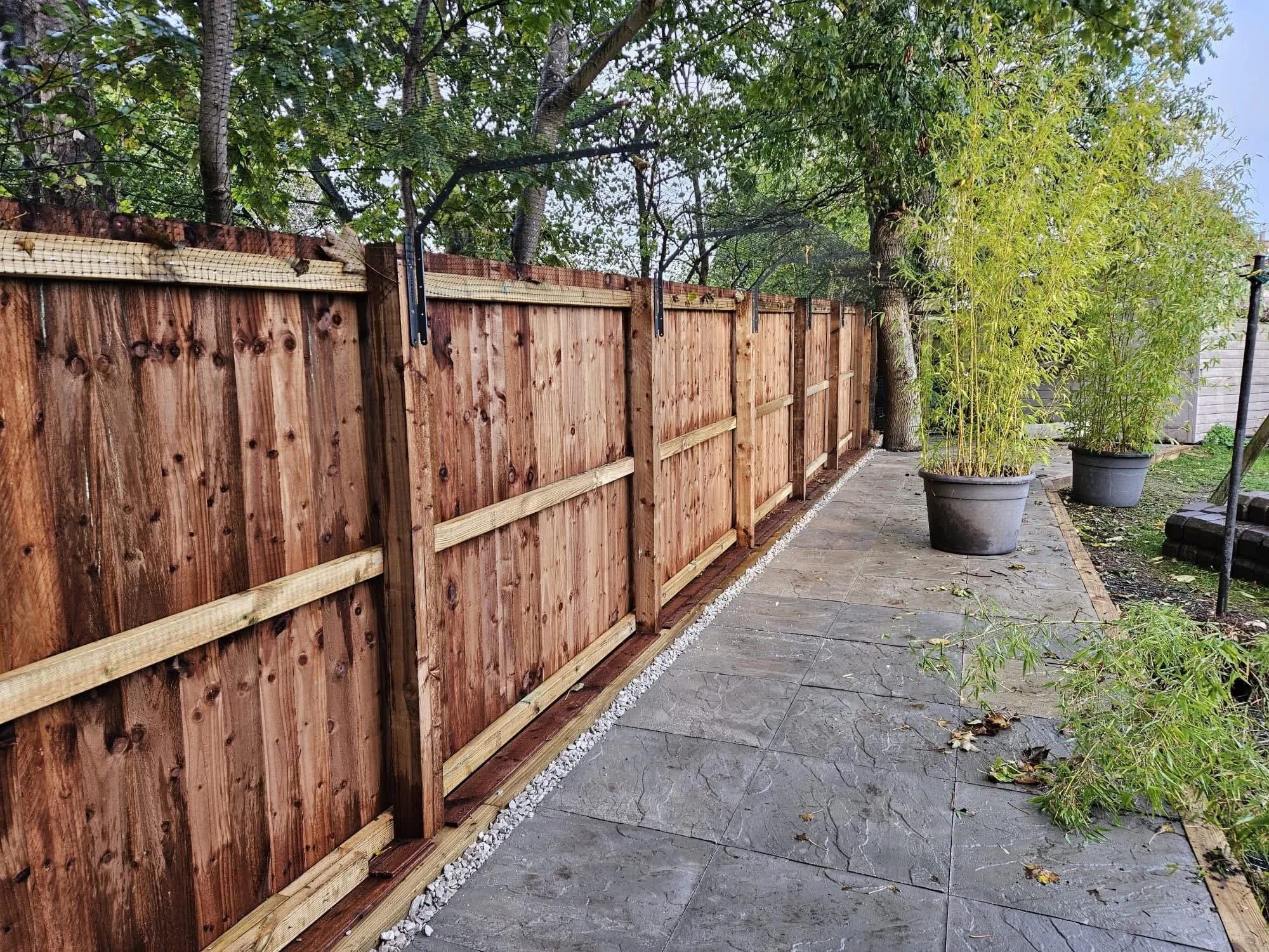 Our customer was in desperate need of a space for their cats to safely roam the garden. We installed 10 bays of feather board fencing to replace the old, damaged fence. We also installed a hard standing area finished in utility paving. 