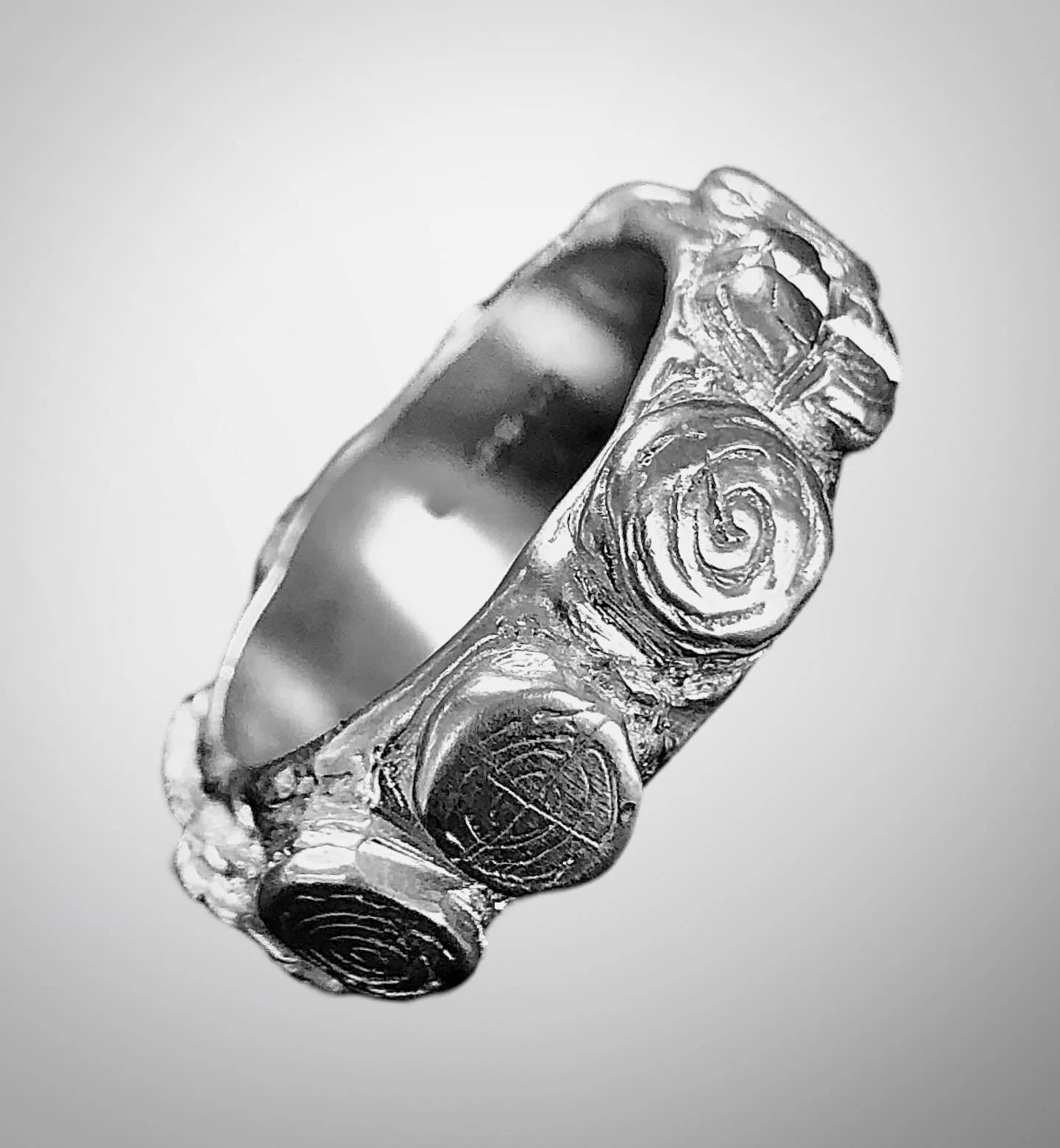 Towie ball ring in recycled sterling silver. 
The Towie Ball was found at Glaschul Hill in Aberdeenshire, North East Scotland. This mysterious stone ball is carved with intricate spiral patterns on each of its faces. Similar designs can be found at N