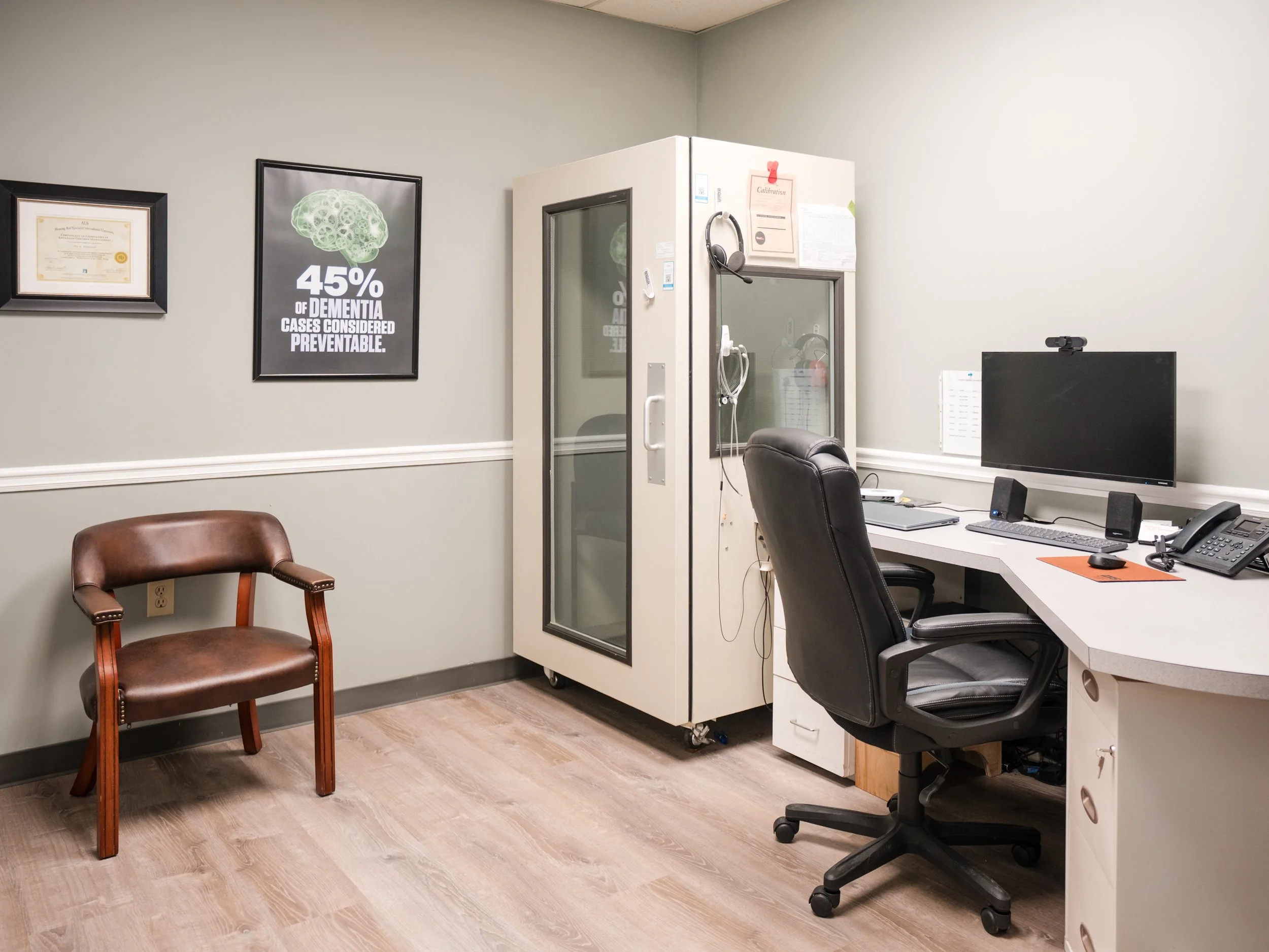 Cross-section of a model of the human ear showing inner ear structures on a white base against a light blue background.