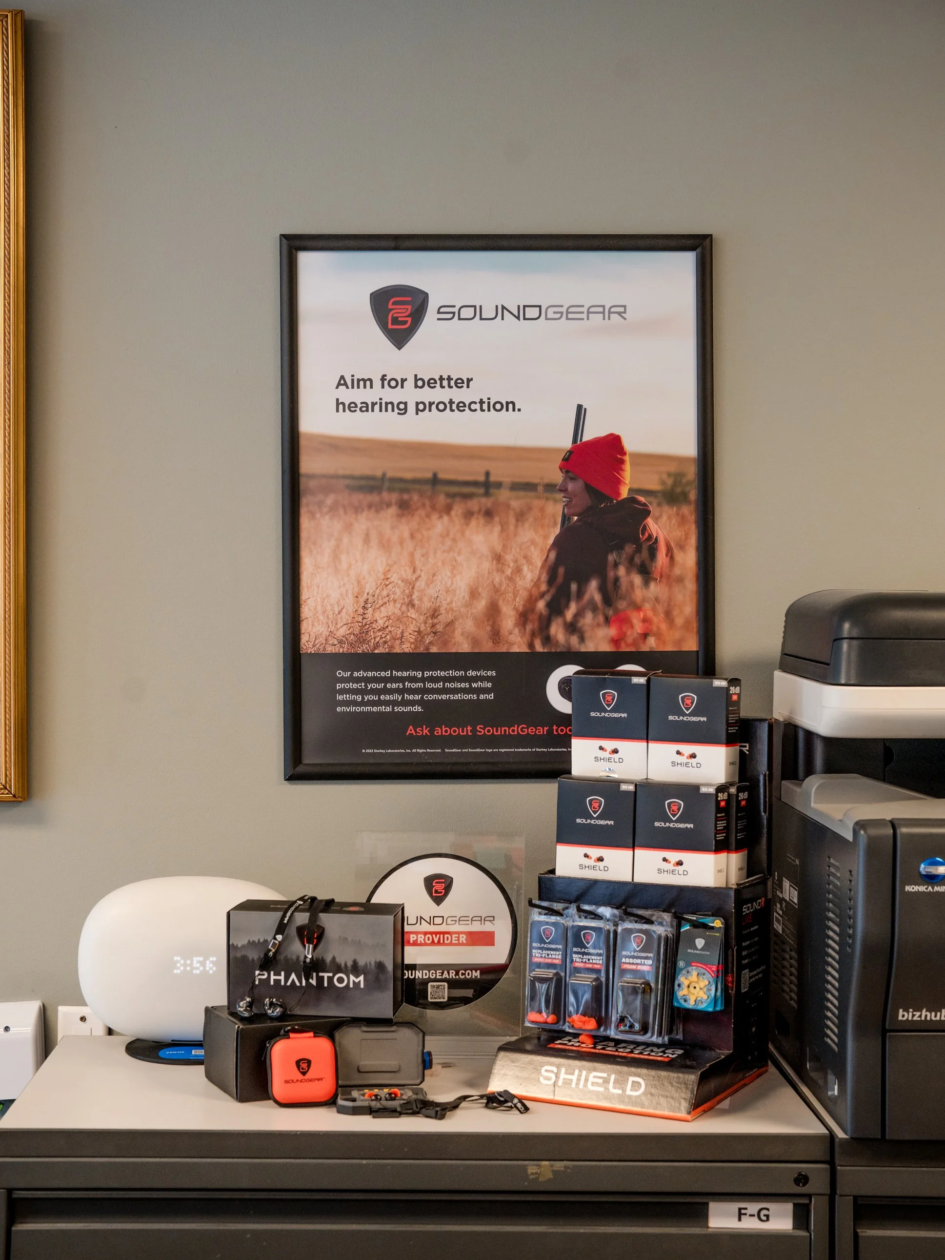 A person holding a yellow earplug close to their ear.
