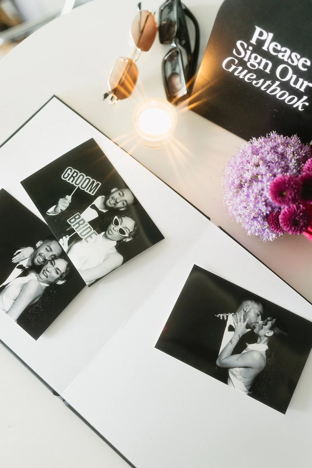 Photo booth with black and white photobooth strip showing images of a couple in wedding attire, holding props and kissing.