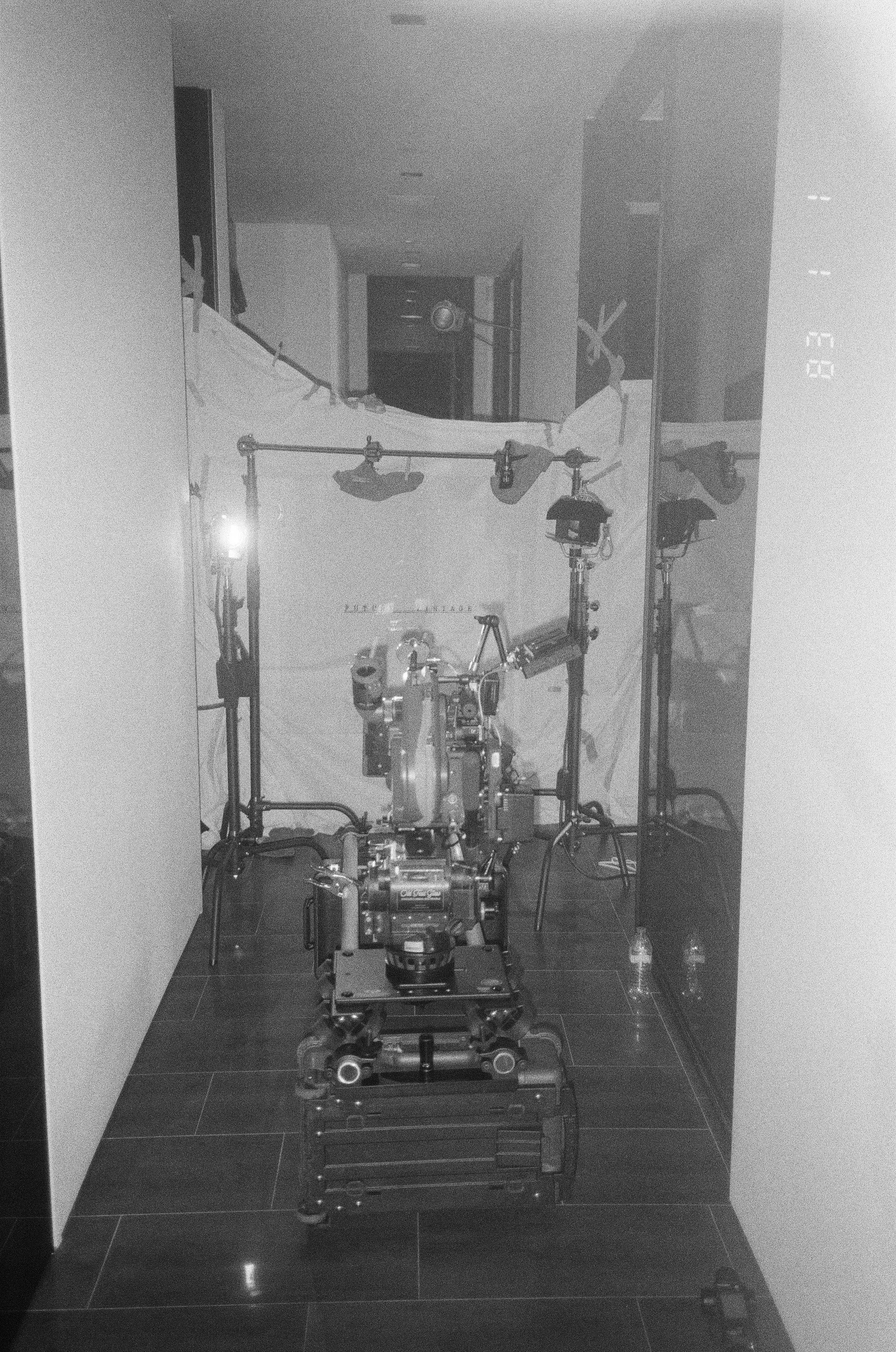 A camera dolly tracks down a hallway toward the lit Future Vintage backdrop.