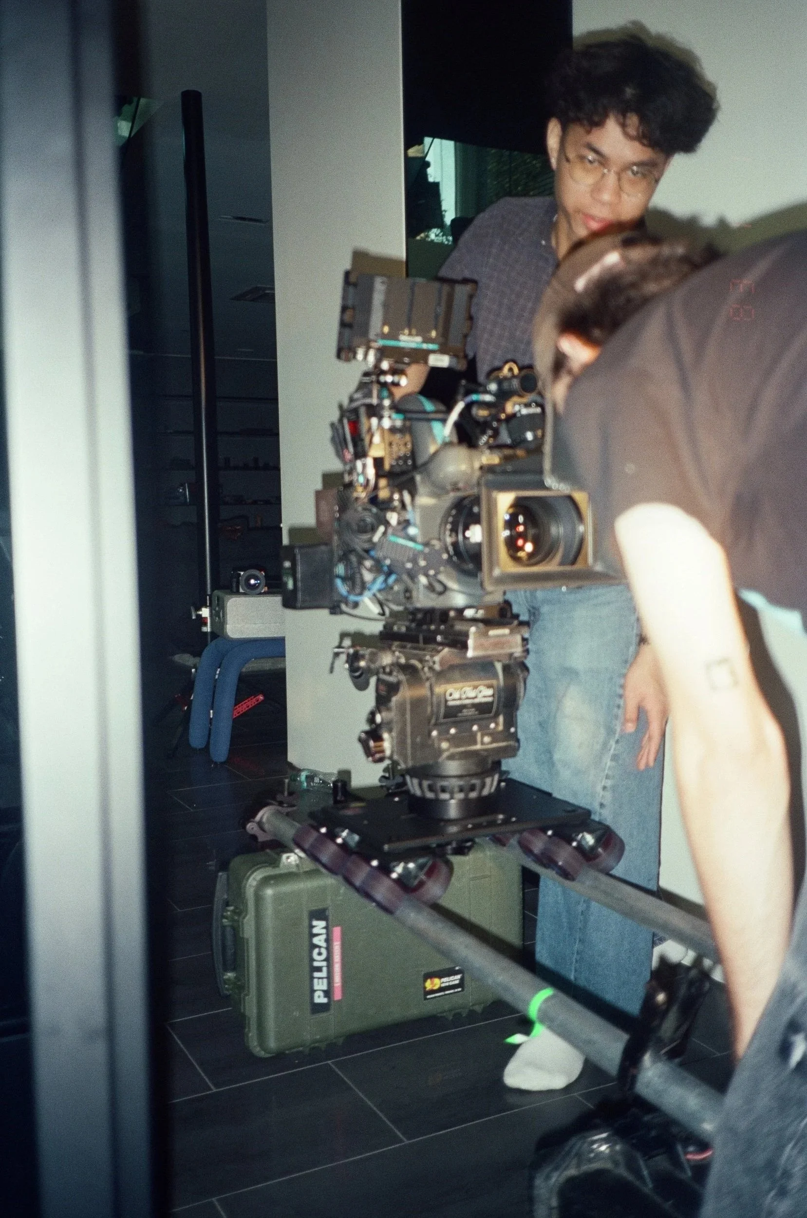 A crew member rests beside the rig and the Pelican cases.