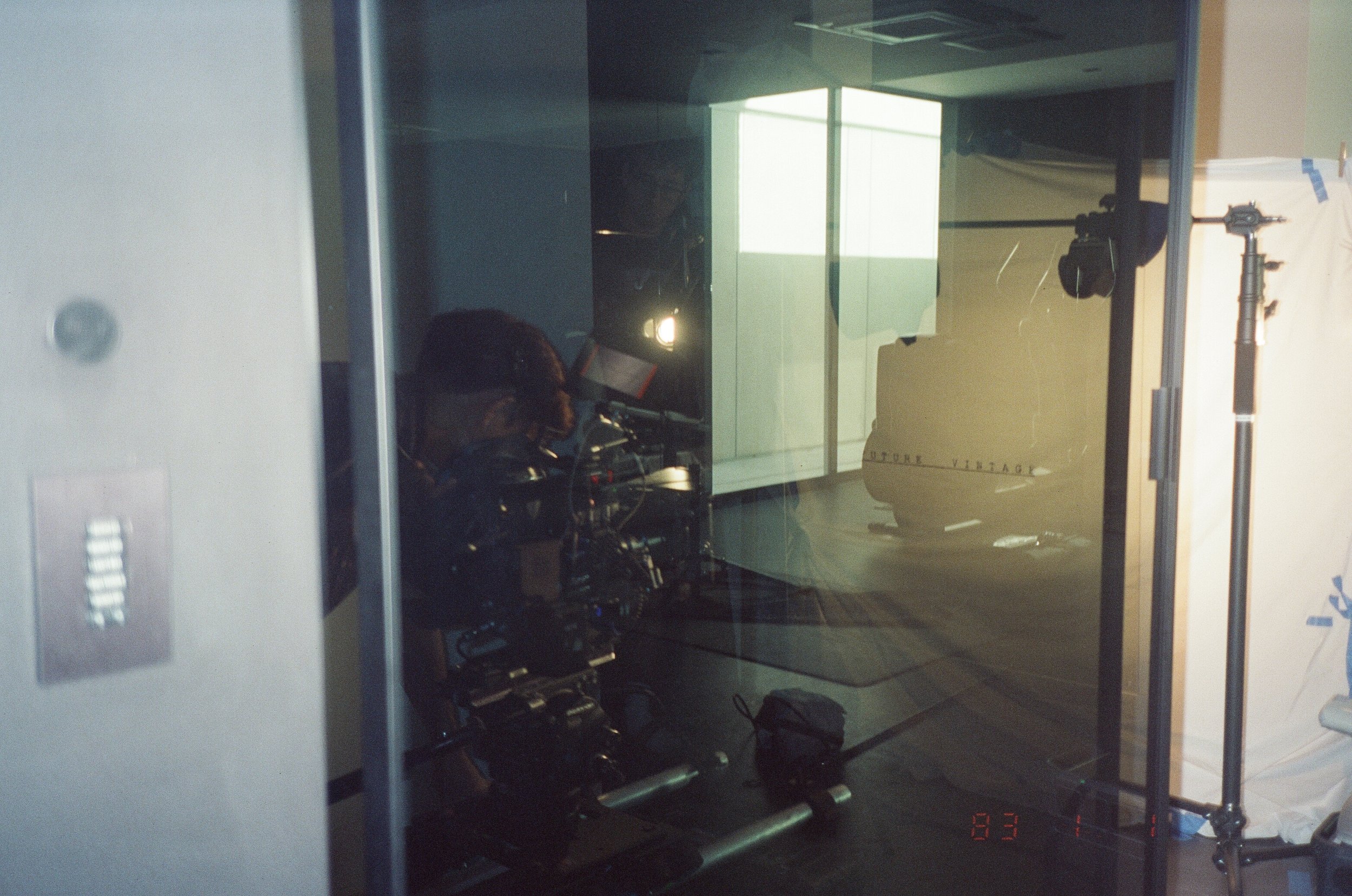 An operator and the rig reflected in glass, the backdrop beyond.