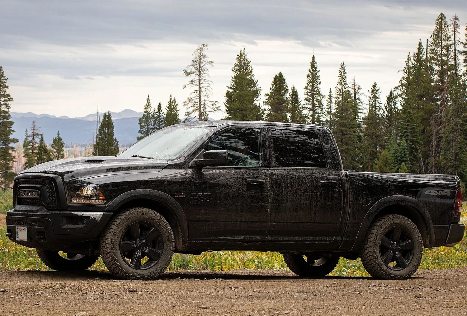 Off-road vehicle parked at a scenic Sierra Nevada overlook with forested mountains in the background.