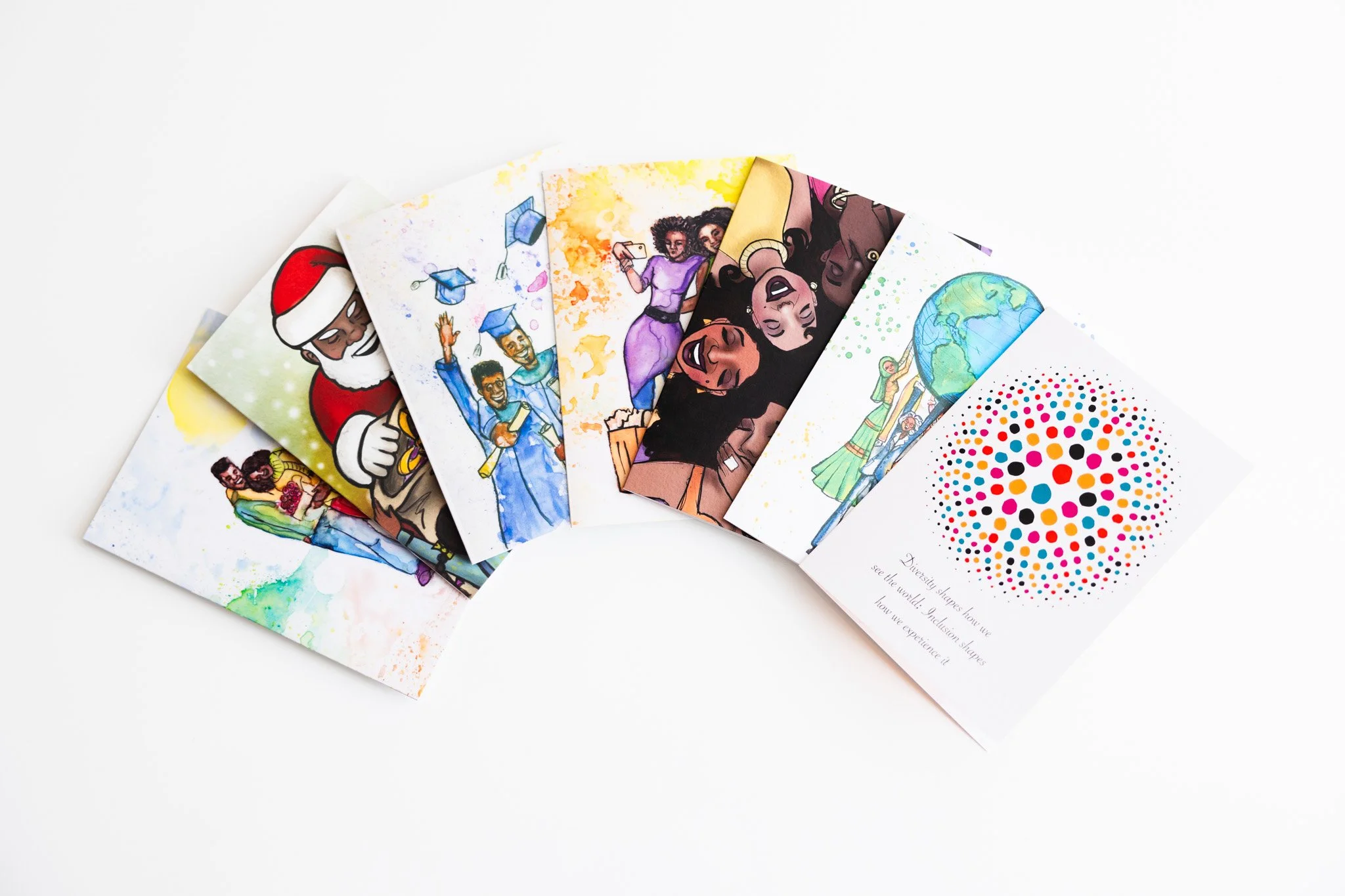 A collection of colorful illustrated greeting cards fanned out on a white surface.