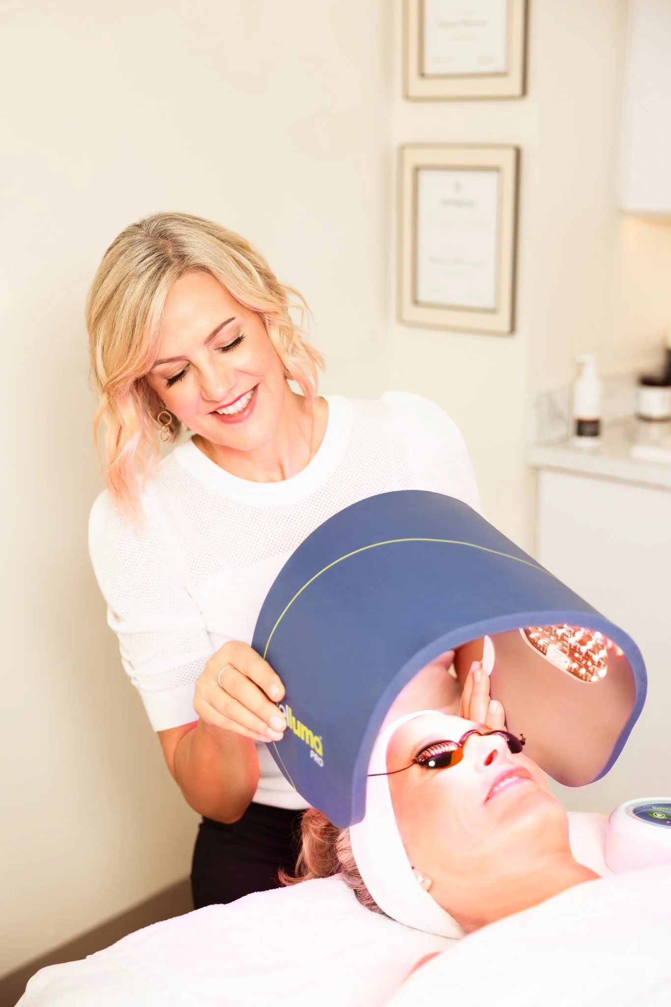 one woman smiling while giving a facial to another woman