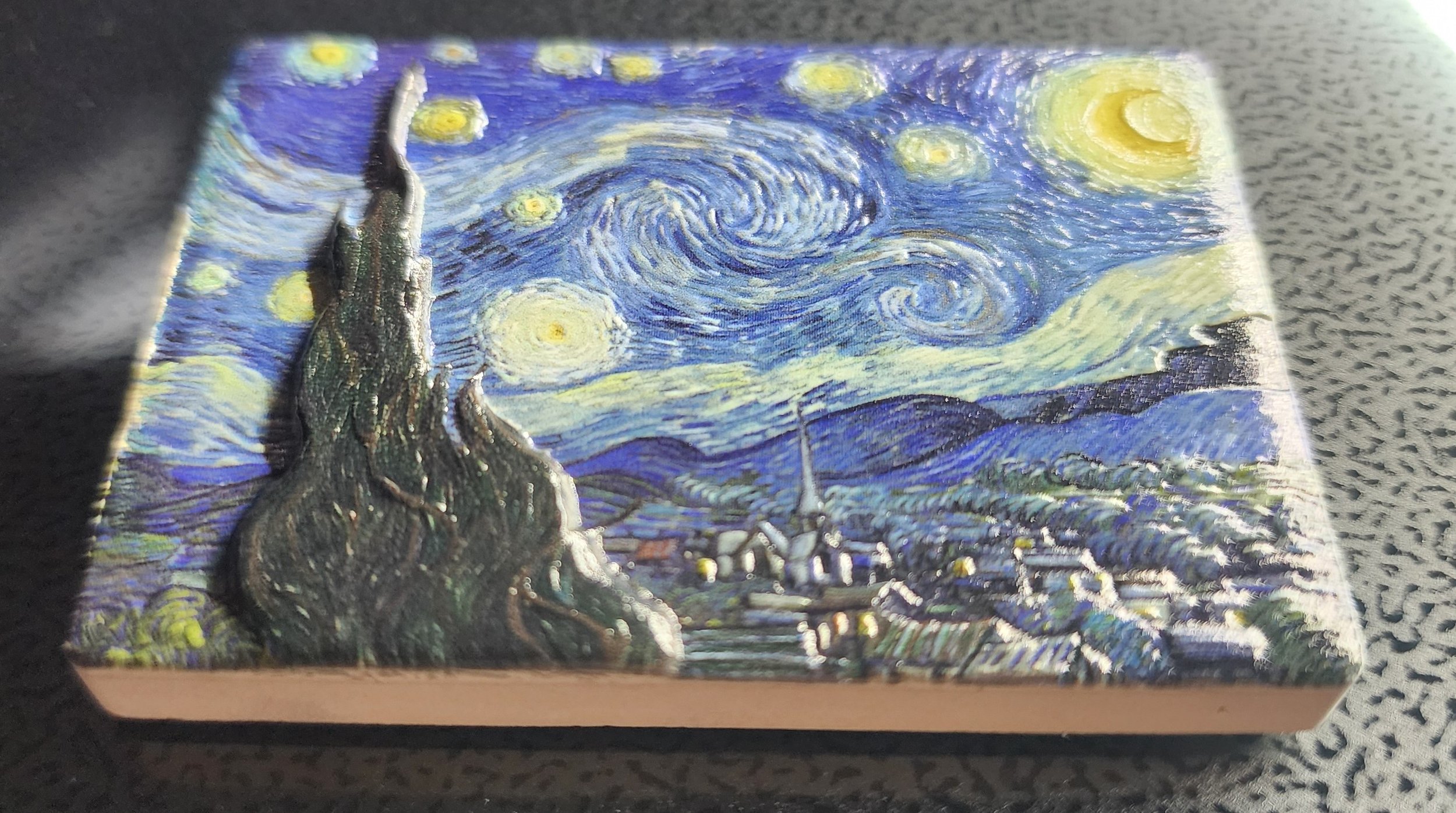 A small rectangular box with a reproduction of Vincent van Gogh's starry night painting on its surface.