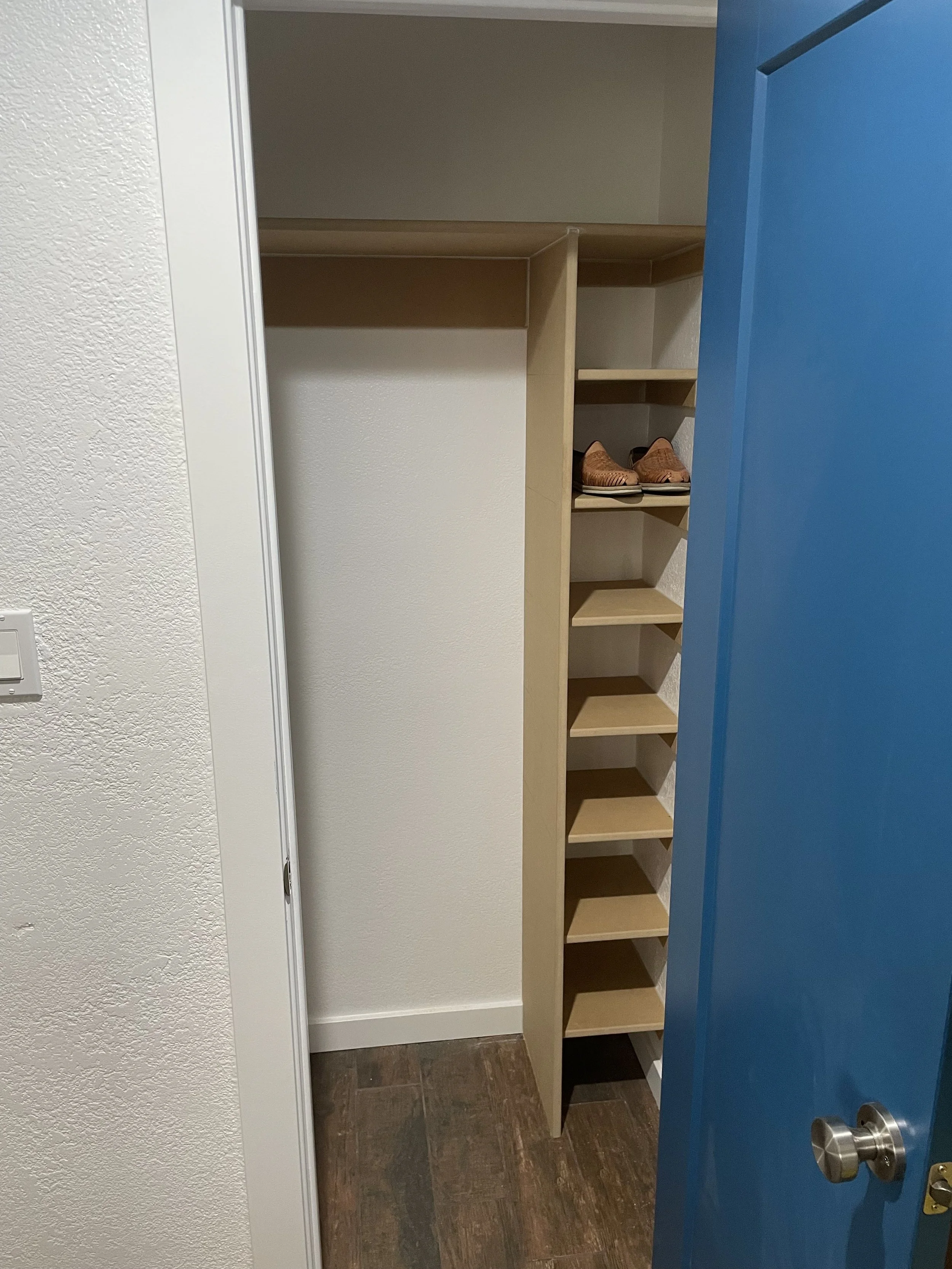 A custom built, shoe rack and shelf to help optimize space and make the area feel more useful.