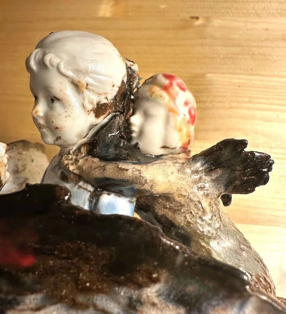 Close-up of a sculpture featuring a child's face and underwater scene with aquatic elements, possibly made of ceramic or similar material.