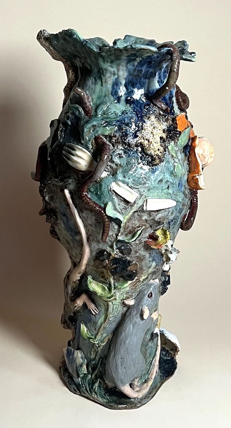 Ceramic sculpture vase with textured, colorful design featuring various animals and figures, including worms, mice, and a rat, in a glossy finish.