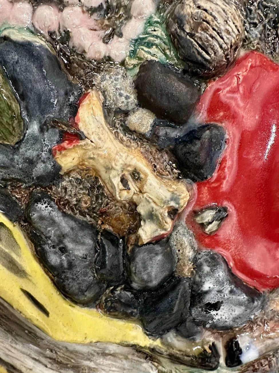 A close-up of a trompe l'oeil ceramic surface witb apple core and banana peel