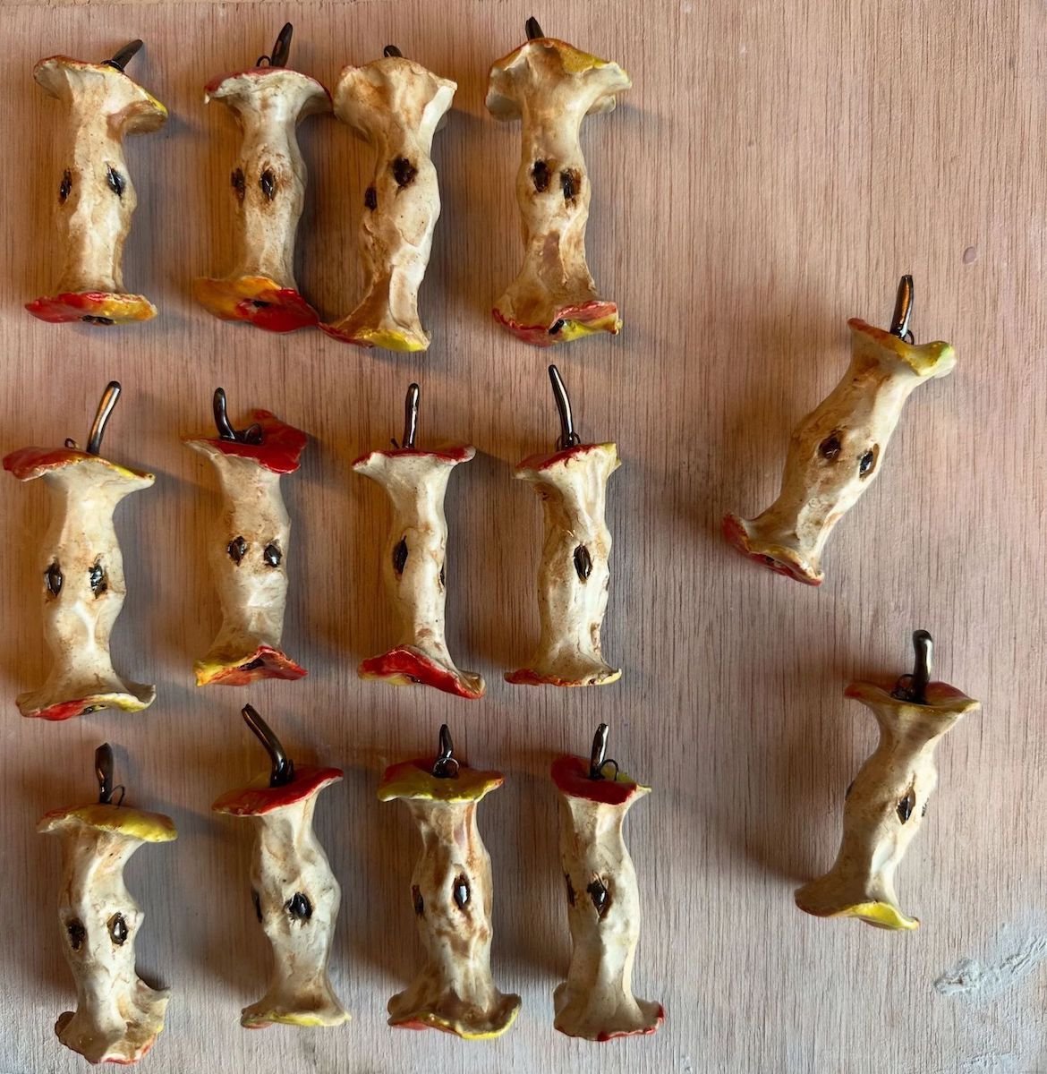 Collection of ceramic apple cores on a wooden board.