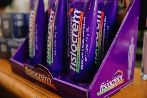 Multiple tubes of Fisioreem gel in purple packaging on a display tray.