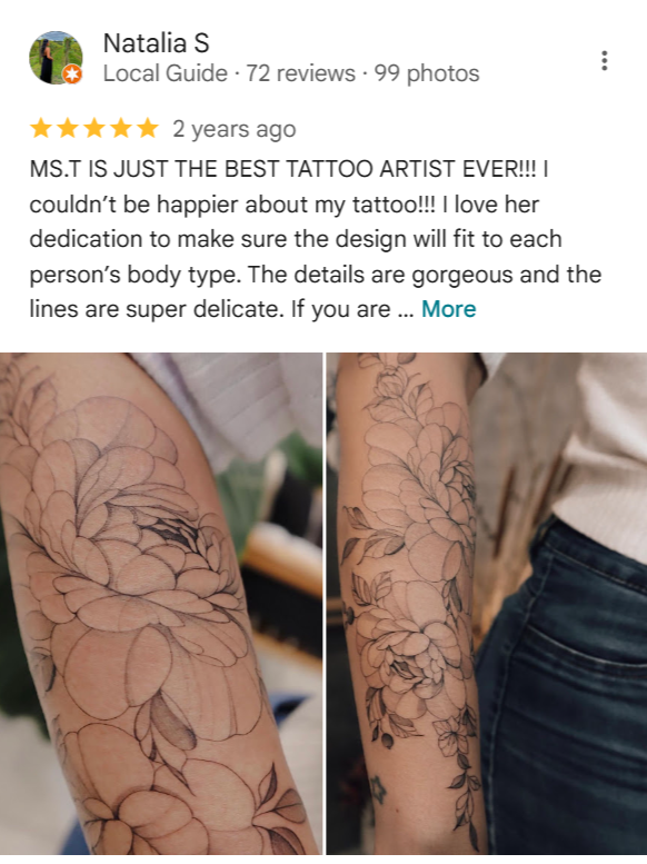 Close-up of a person's forearm showing a detailed floral tattoo with delicate line work and large blooming flowers.