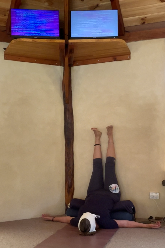 Tara practising a yoga pose with her legs up the wall in the Hemple with EESystem units.