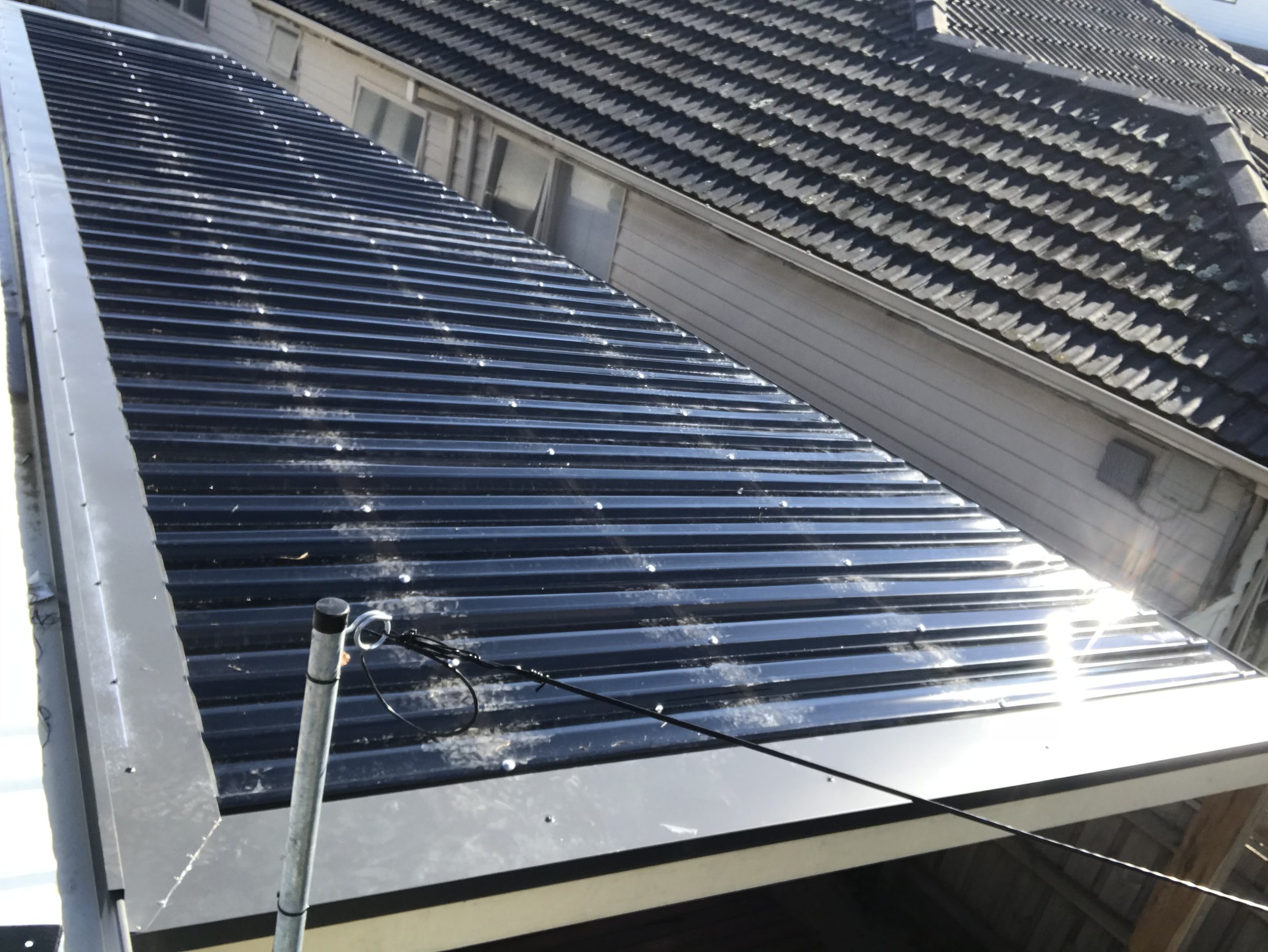 Solar panels installed on a house roof with a window visible on the side.