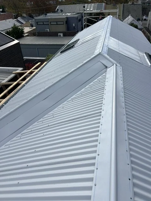 Close-up of a silver corrugated metal roof with multiple sections, seen from above.