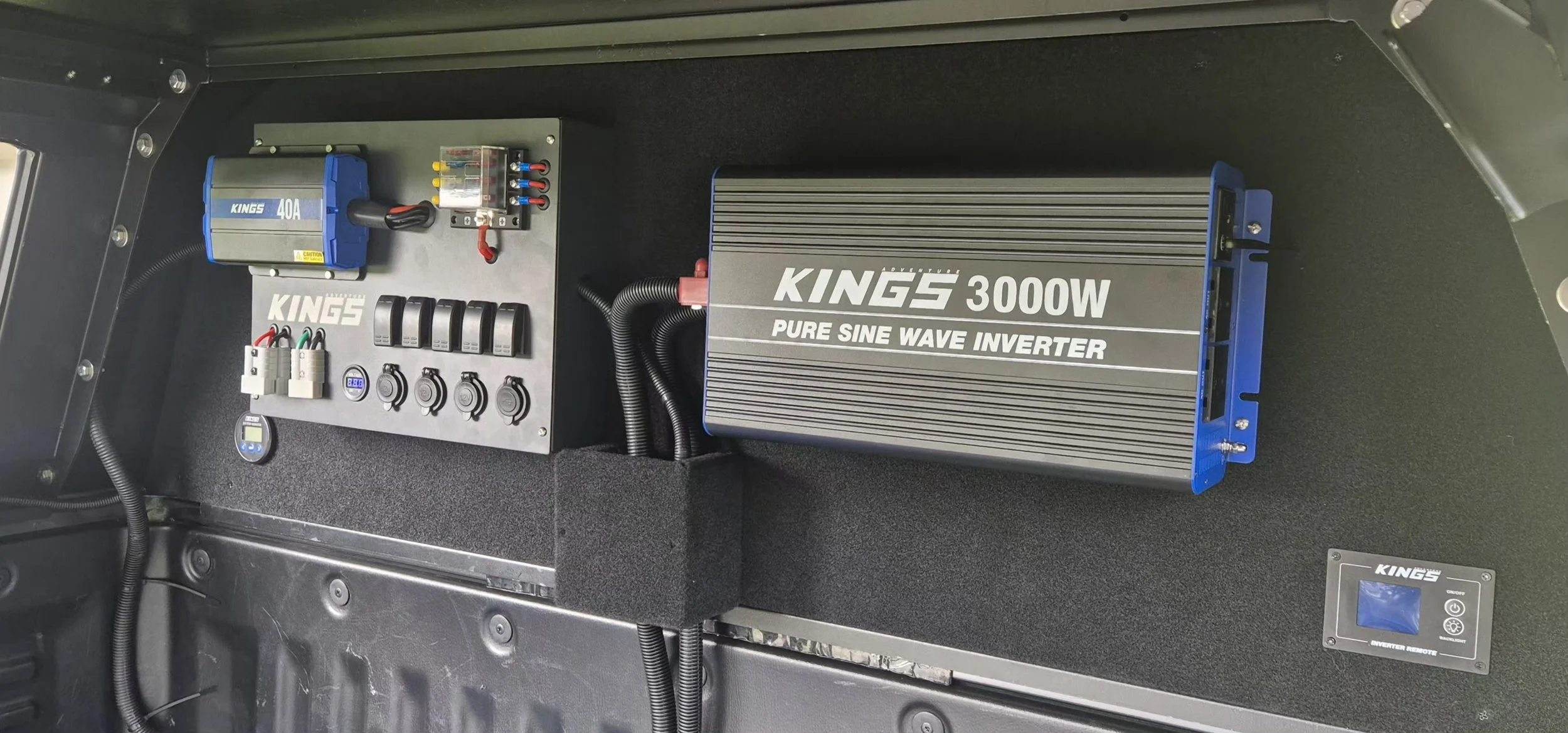 View of an electrical control panel and a large inverter labeled KING5 3000W Pure Sine Wave Inverter installed inside a vehicle or equipment compartment.