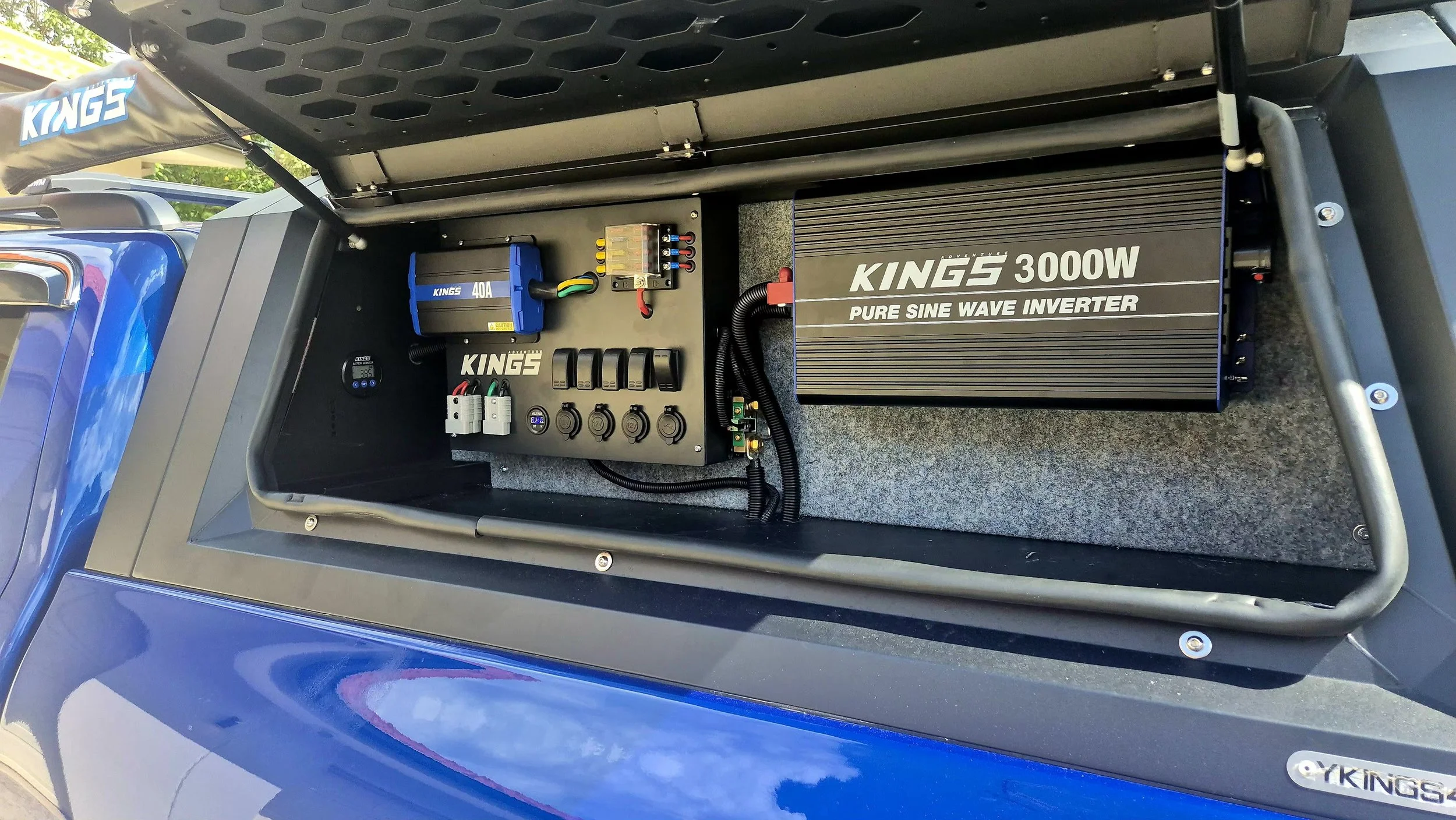 Open compartment containing a blue Kings 40A fuse box, a Kings 3000W pure sine wave inverter, a circuit breaker panel, and various electrical connections and switches.