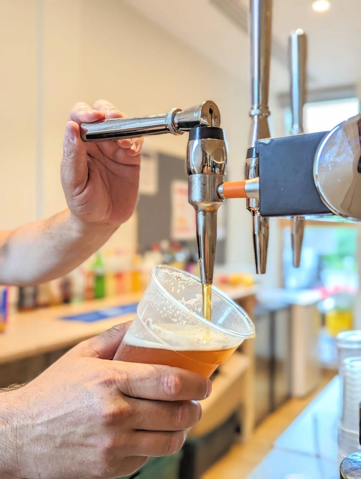 hand pulling beer tap down pouring berr into a pint glass