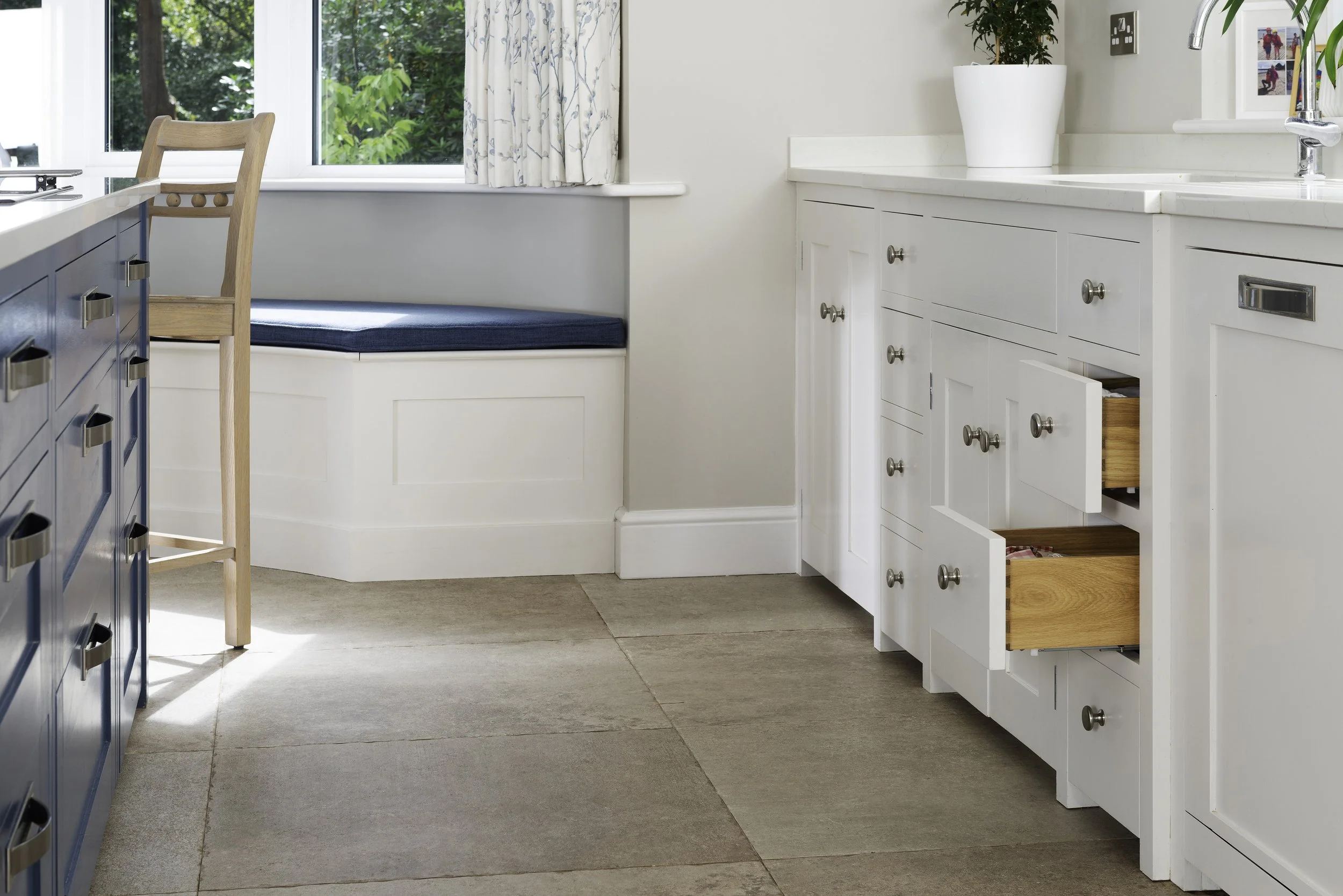 Break front sink cabinet and cubbyhole drawers. The curved window seat has hinged lids for extra storage.
