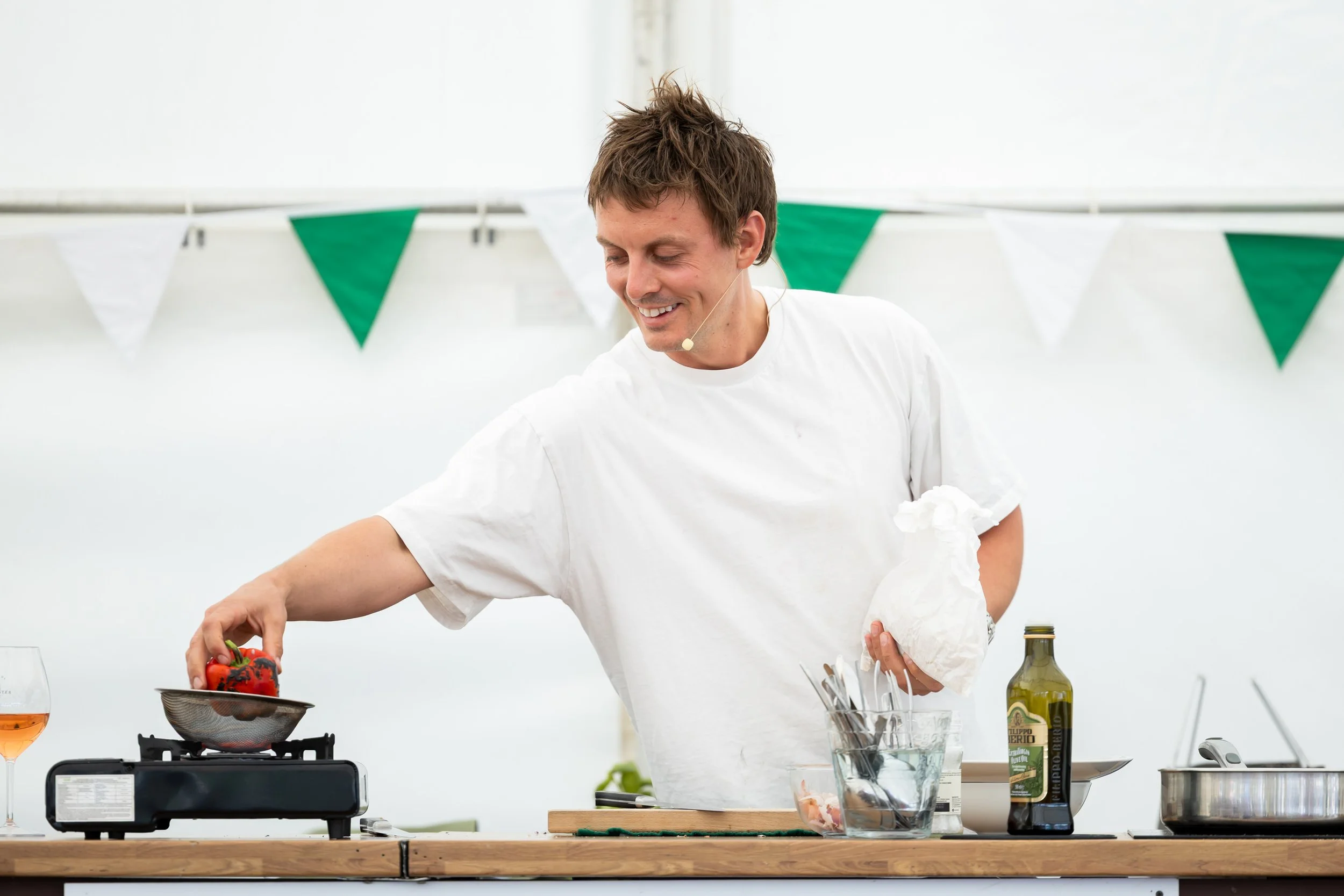 Thomas Straker chef smiling cooking with peppers on stove at the Blenheim Food Festival