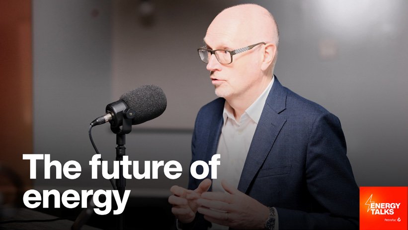 A man in a suit and glasses speaking into a microphone during a podcast or interview titled 'The future of energy' with a logo that says 'Energy Talks' in the bottom right corner.