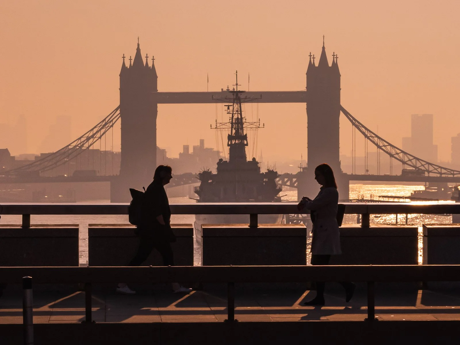Two people crossing London Bridge in early morning light by Tim Tate.jpg