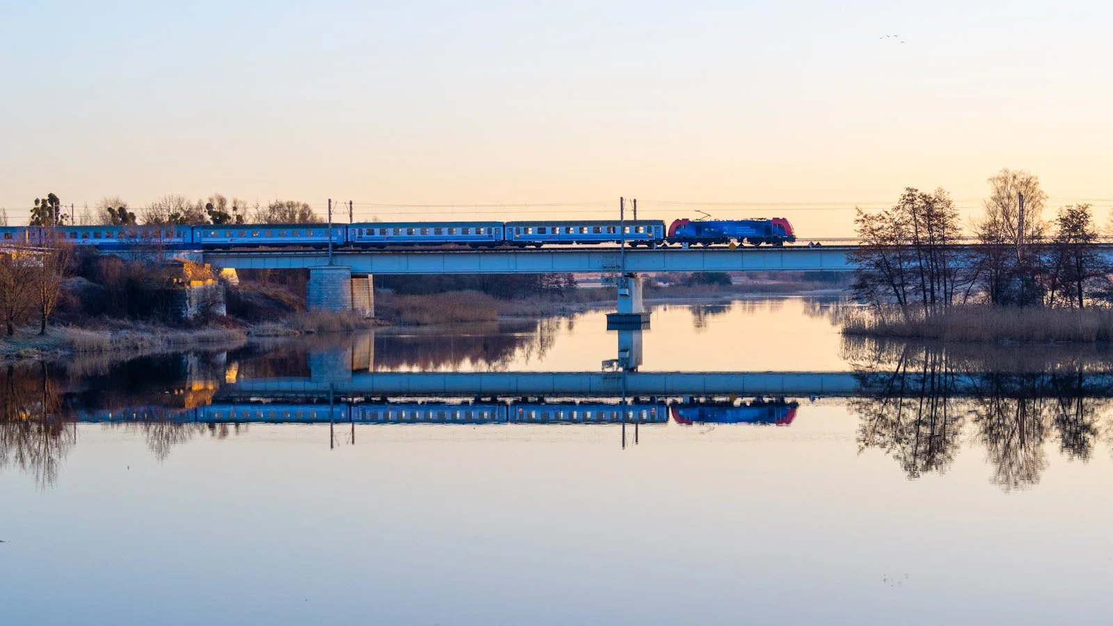 Early morning reflections of train in River Nogat in Poland by Tim Tate.jpg