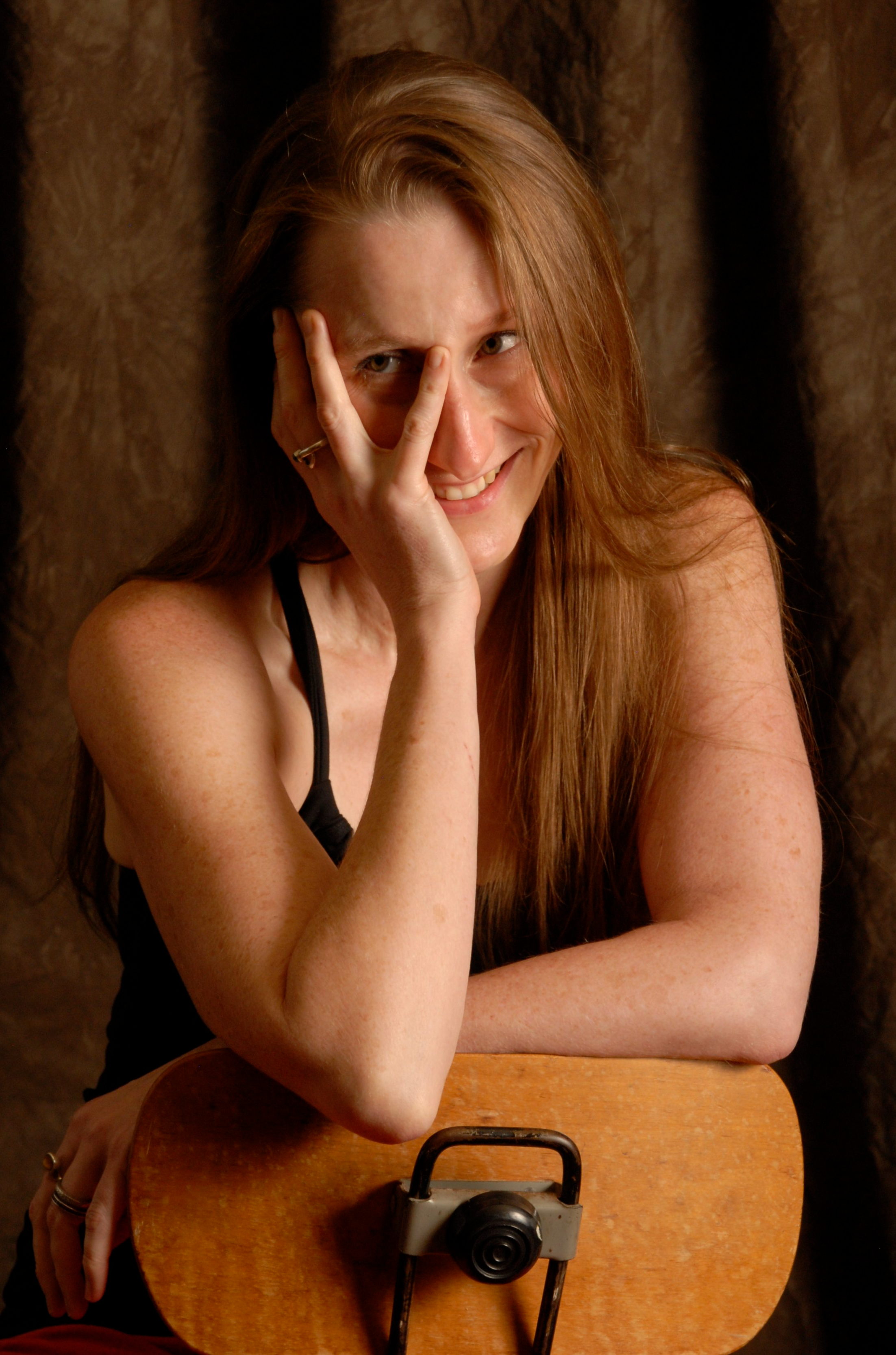 Photo of Amanda K. King, owner of the website, sitting in a chair and smiling.