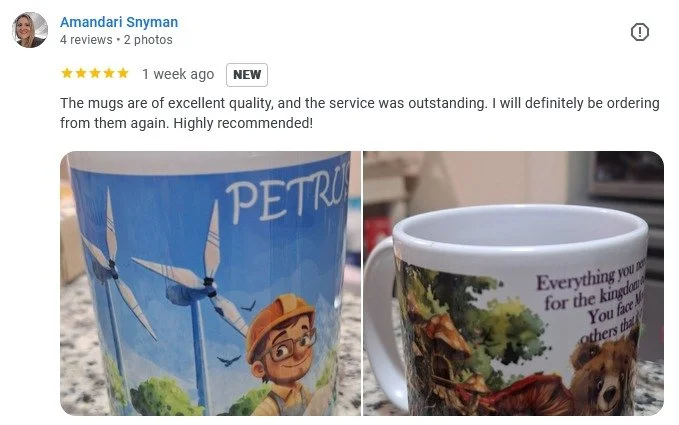 Two ceramic mugs, one with a windmill and cartoon character, the other with a nature scene and bear.
