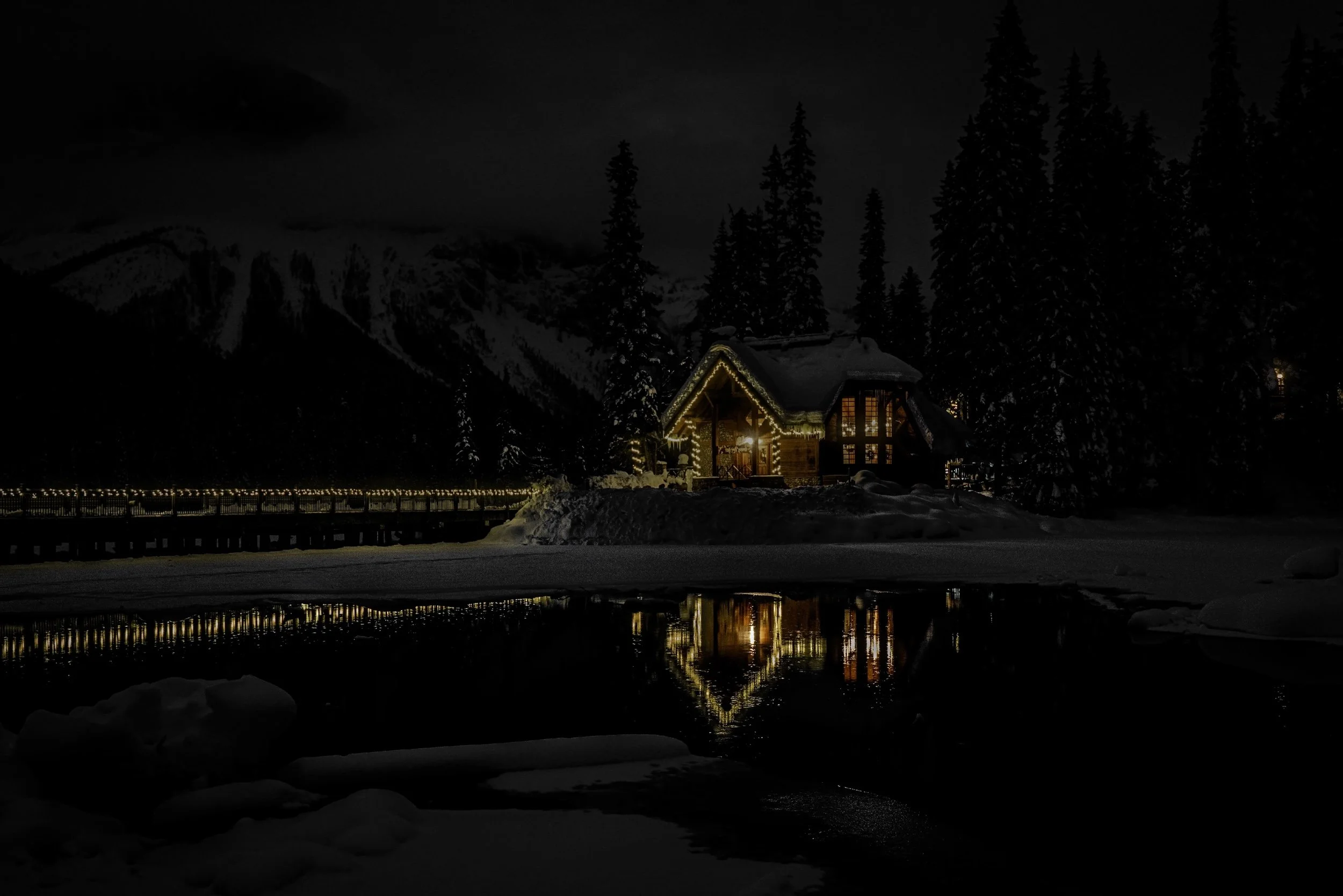 Cilantro on the Lake glowing in the dark with warm reflections in the water and snow all around.