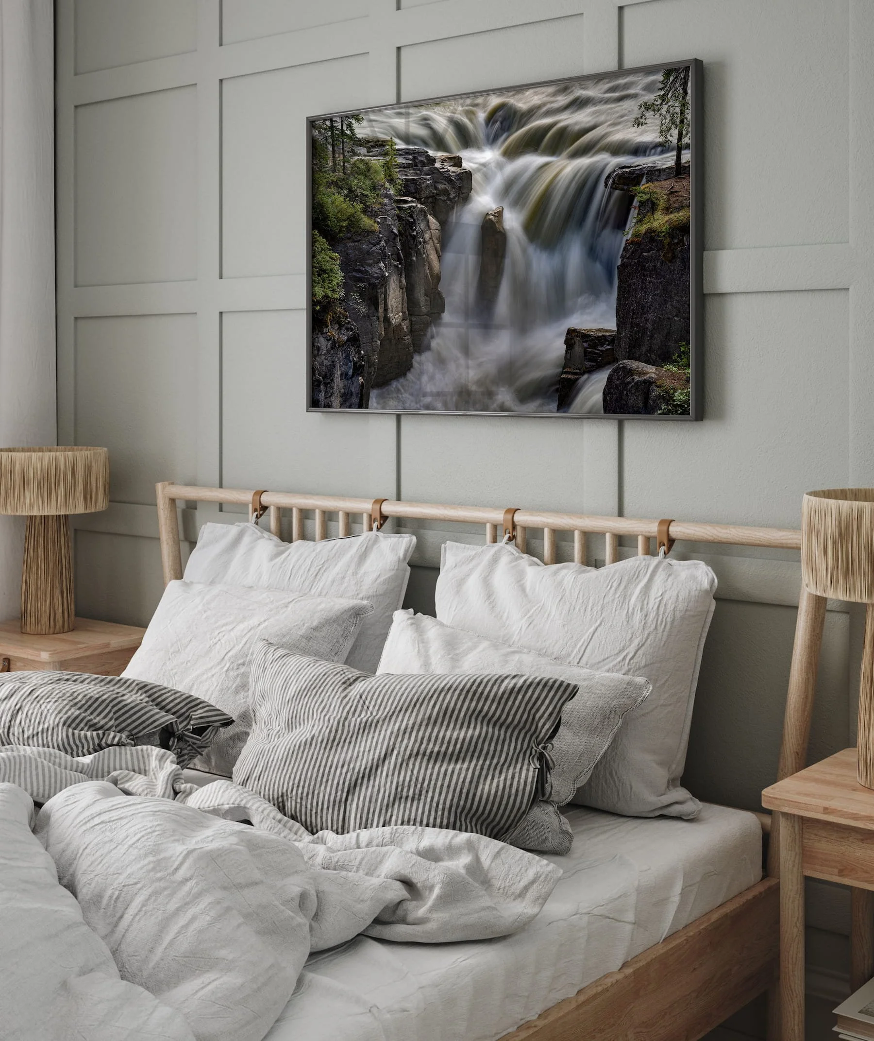 Large framed metal print of Sunwapta Falls on a modern bed, set against a soft gray wall.