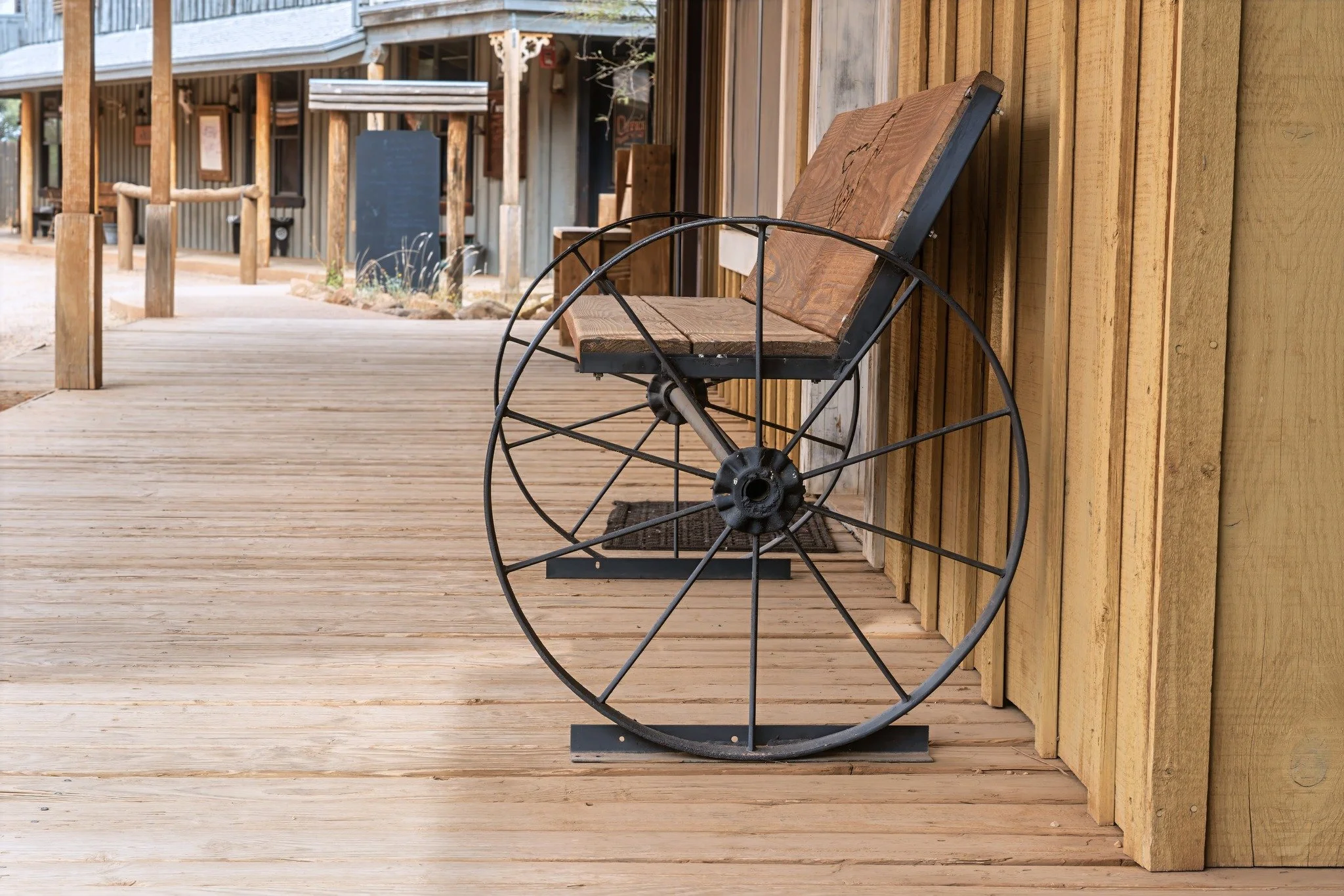 Old West-style guest cabin at Tombstone Monument Ranch with wooden porch and boardwalk.