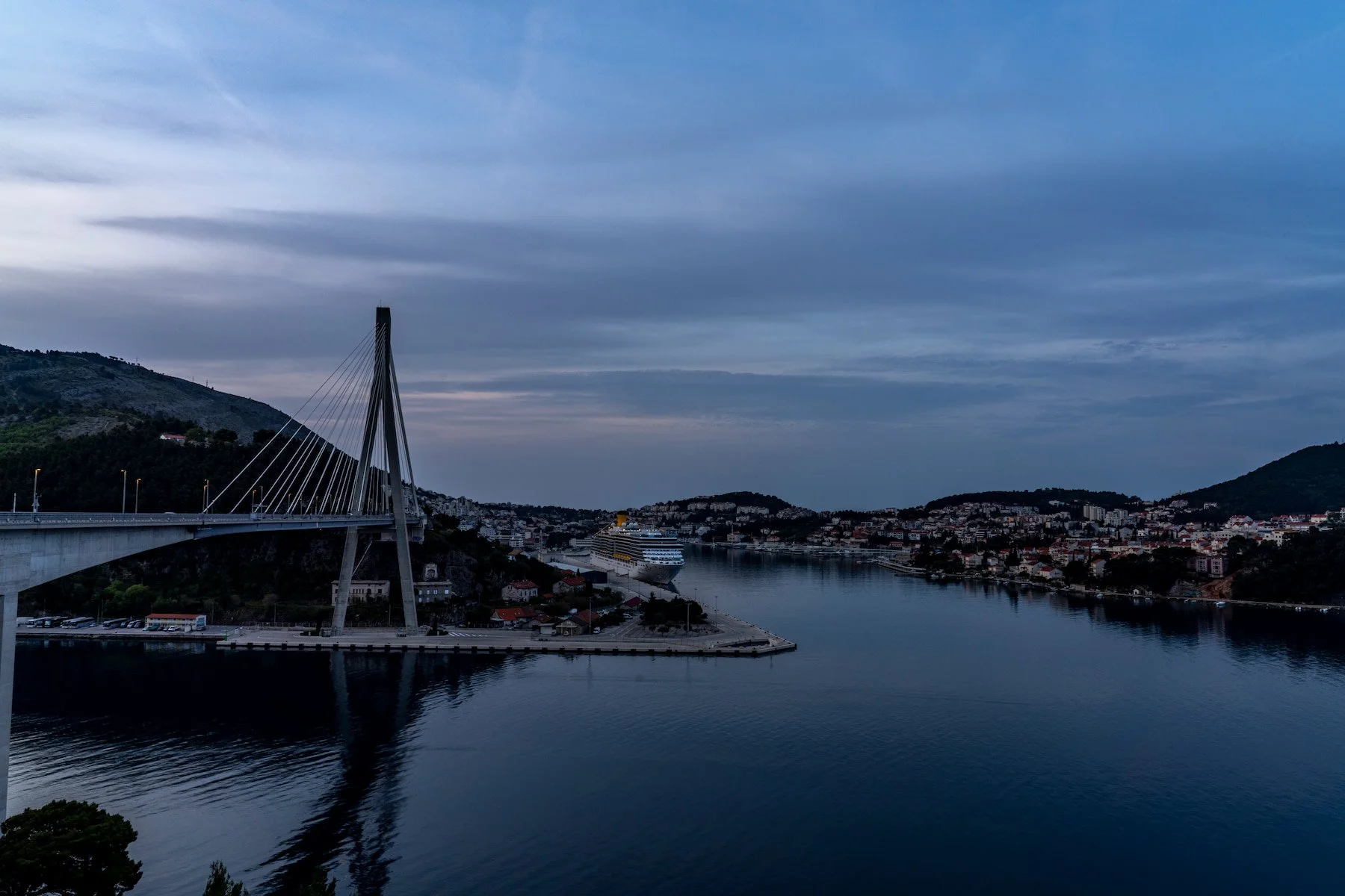 Franjo Tuđman Bridge and Gruž harbour at blue hour with a cruise ship docked.
