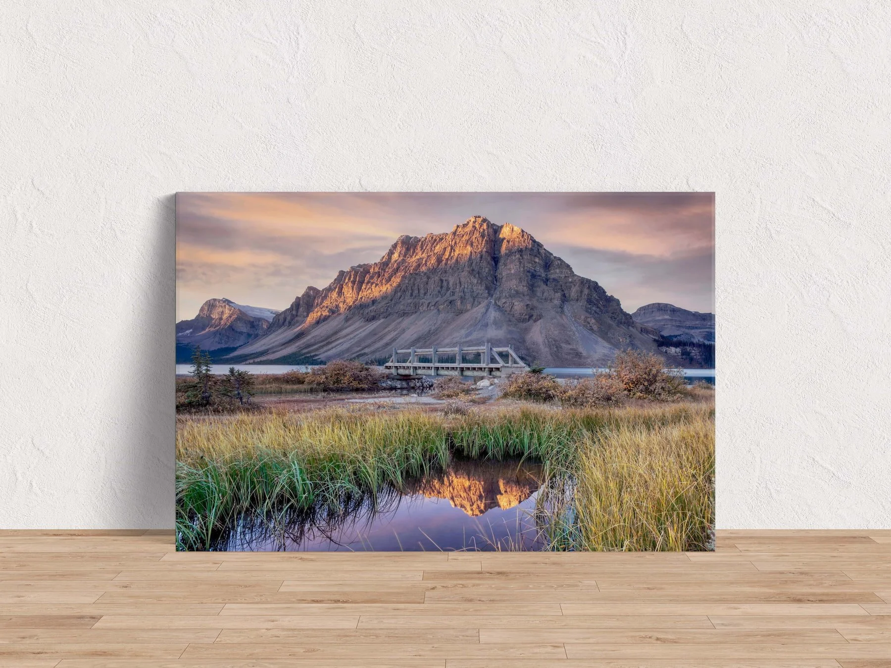 Bow Lake at Dawn gallery-wrapped canvas print leaning against a white textured wall on a light hardwood floor.