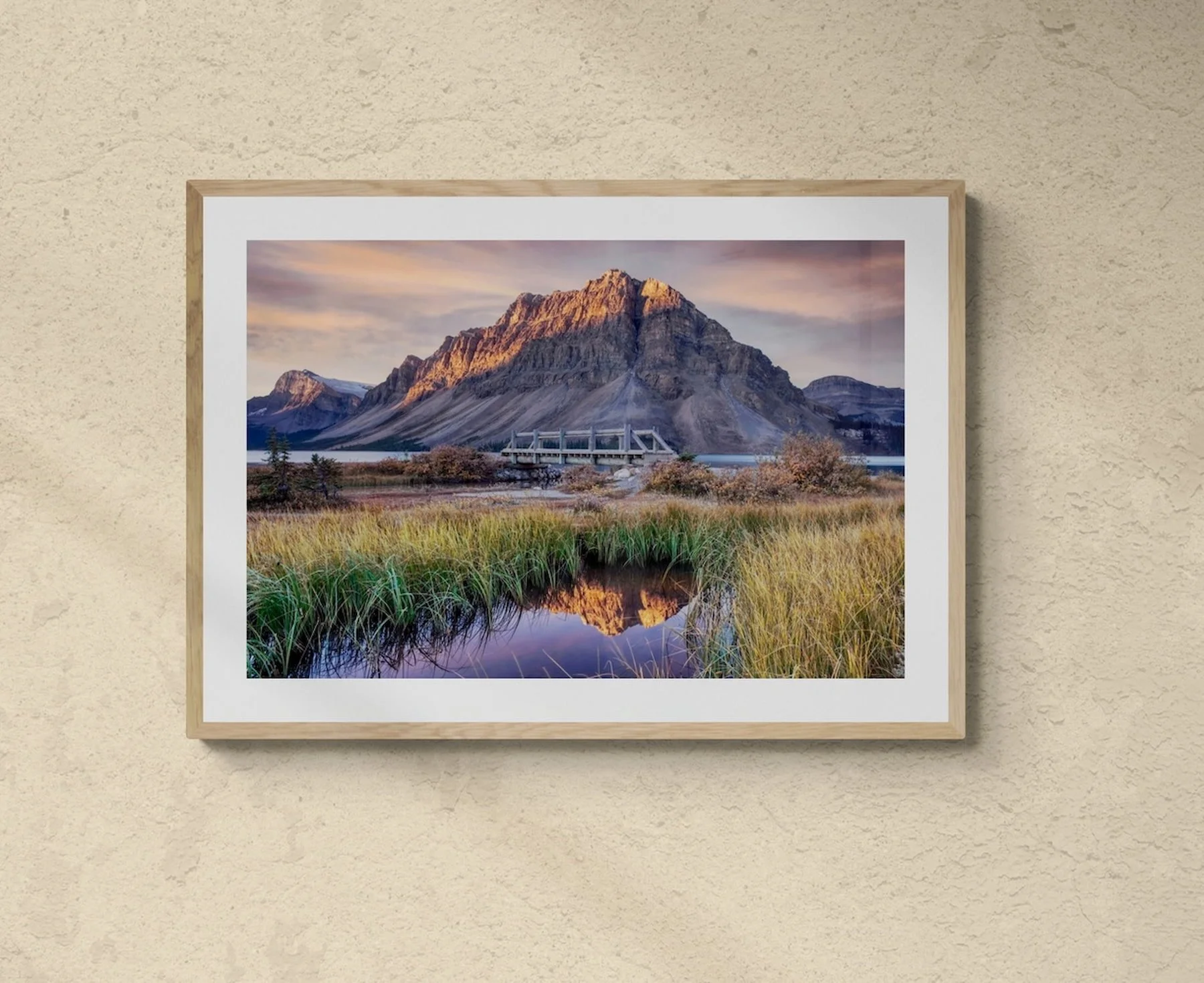 Bow Lake at Dawn fine art print in a sunlit-room with an armchair and tropical plants.