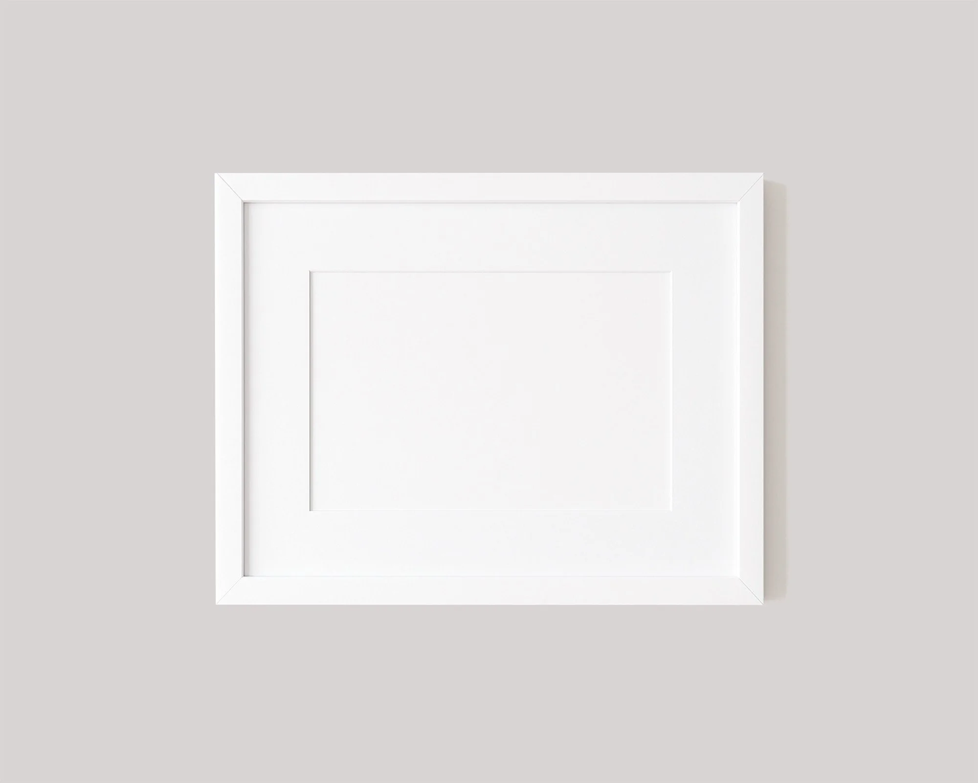 Minimalist landscape white gallery frame with a clean white mat board hanging on a bright wall