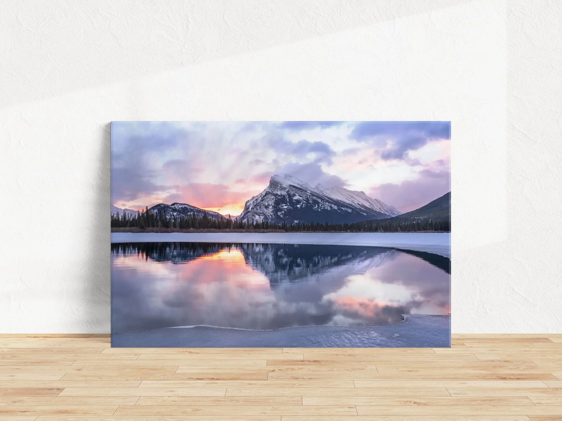 Mount Rundle Reflections gallery-wrapped canvas leaning on white textured wall with a light, hardwood floor.