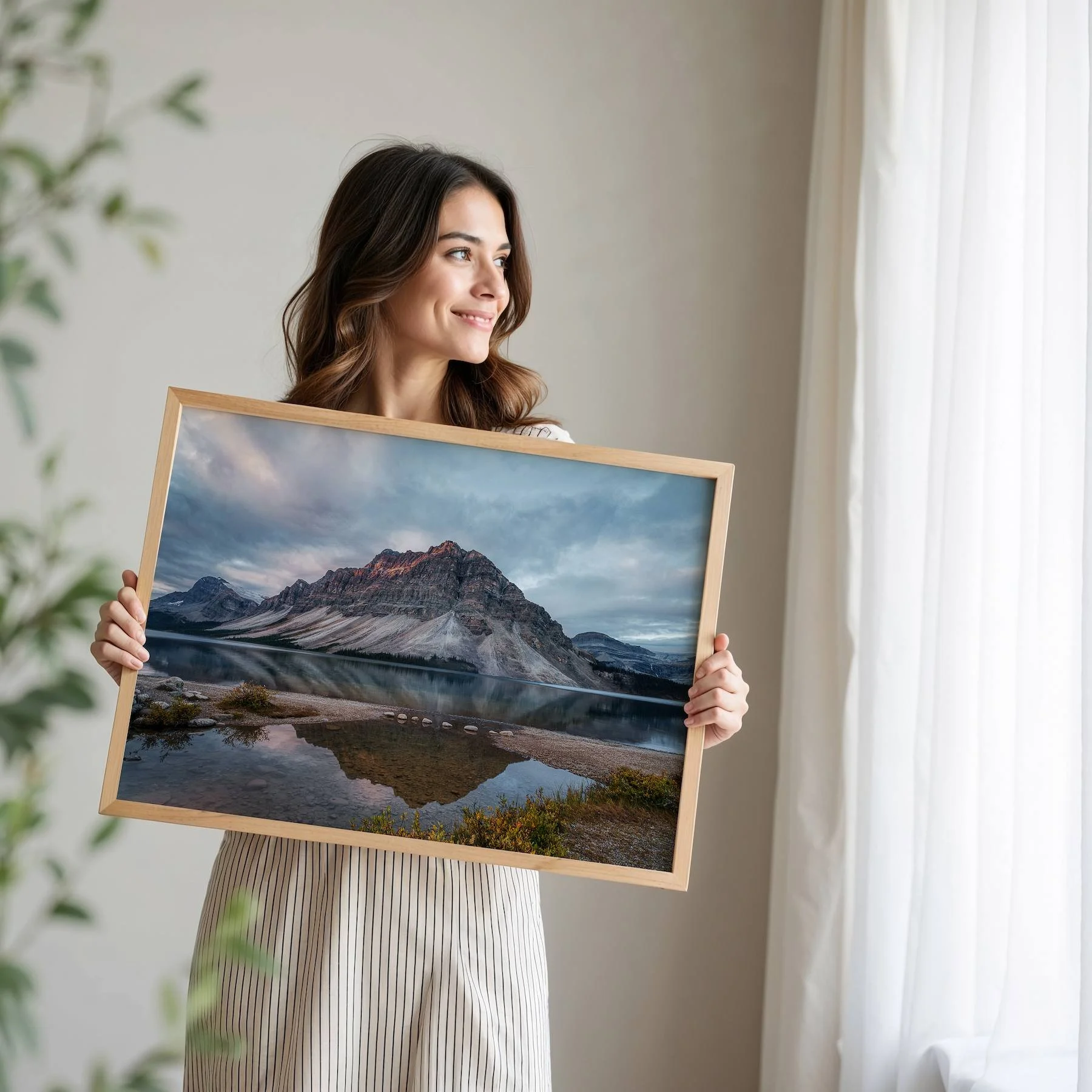 Woman holding framed print of Bow Lake Reflections.