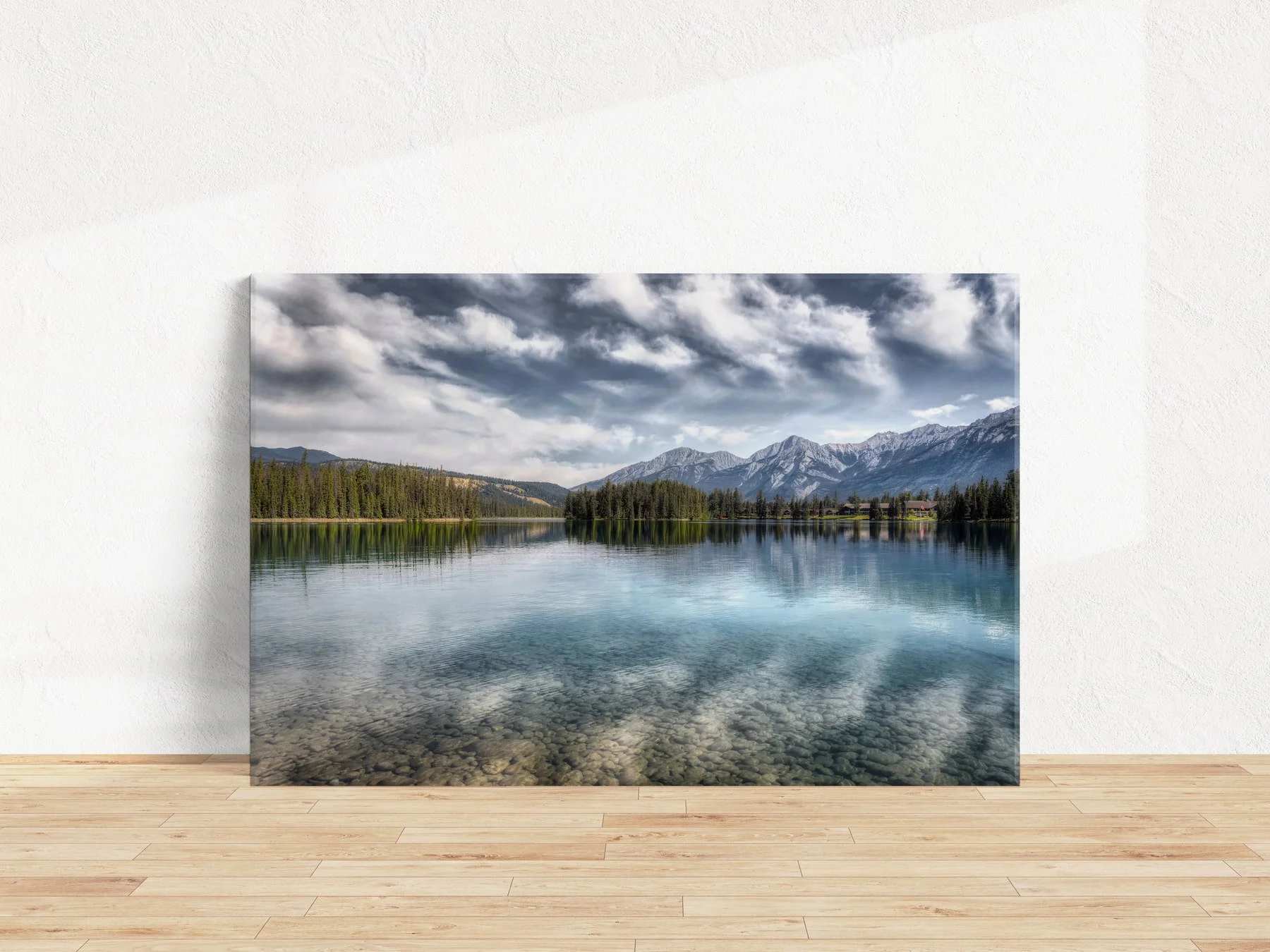 Lac Beauvert Reflections gallery-wrapped fine art canvas print leaning against a white textured wall on a light hardwood floor.