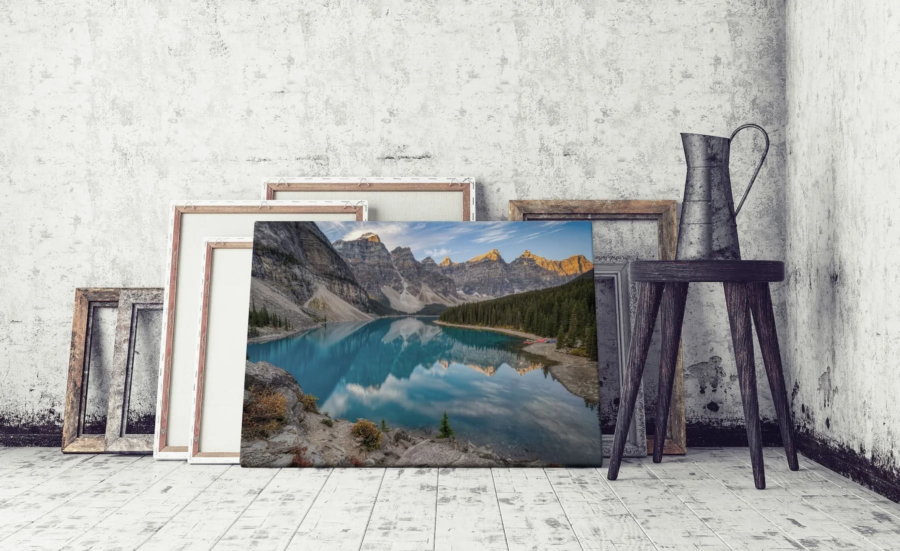 Moraine Lake Sunrise canvas leaning against other prints and frames in a rustic setting.
