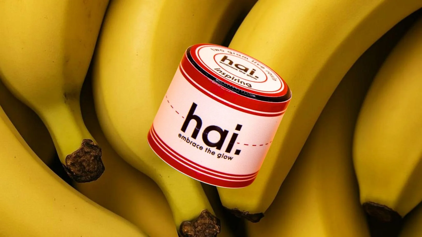 hai. banana lotus live rosin jar photographed against a background of yellow bananas, highlighting the product’s banana-inspired flavor profile.