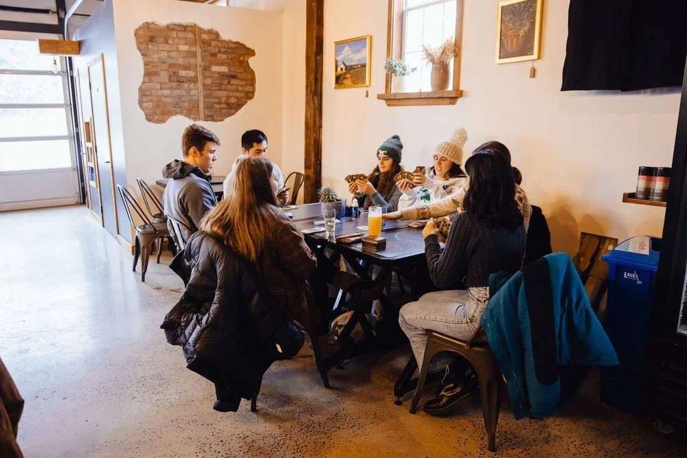 Young adults who have moved to Schoharie County in Upstate New York, playing a card game at New York brewery