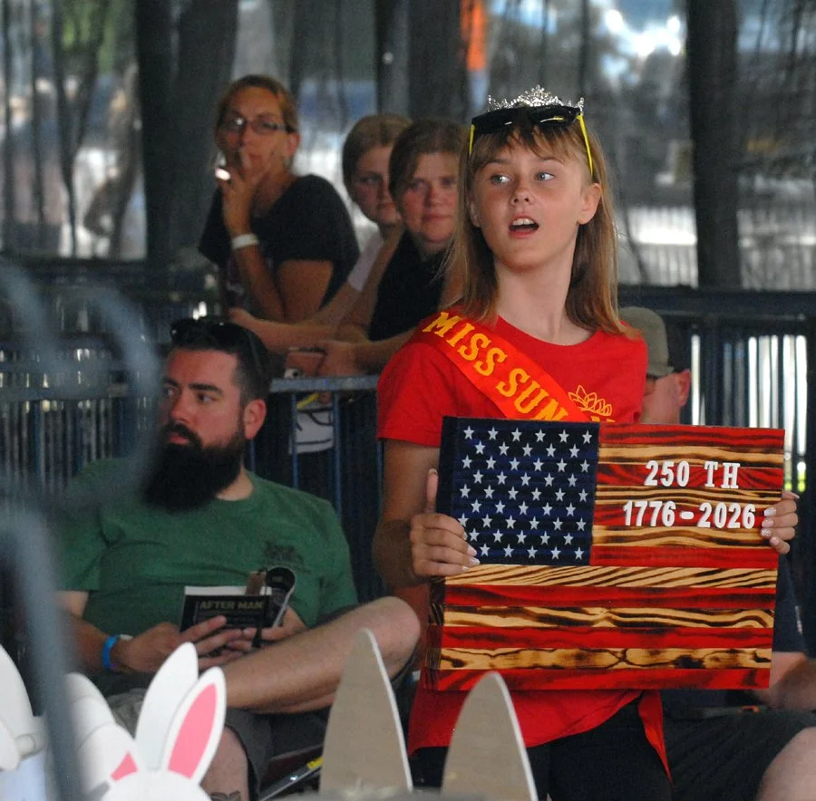 A Fair exhibitor holds up  wooden flag for Saturday's auction.
