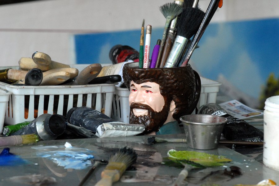 A Bob Ross mug holds artist Bob Strong's tools.