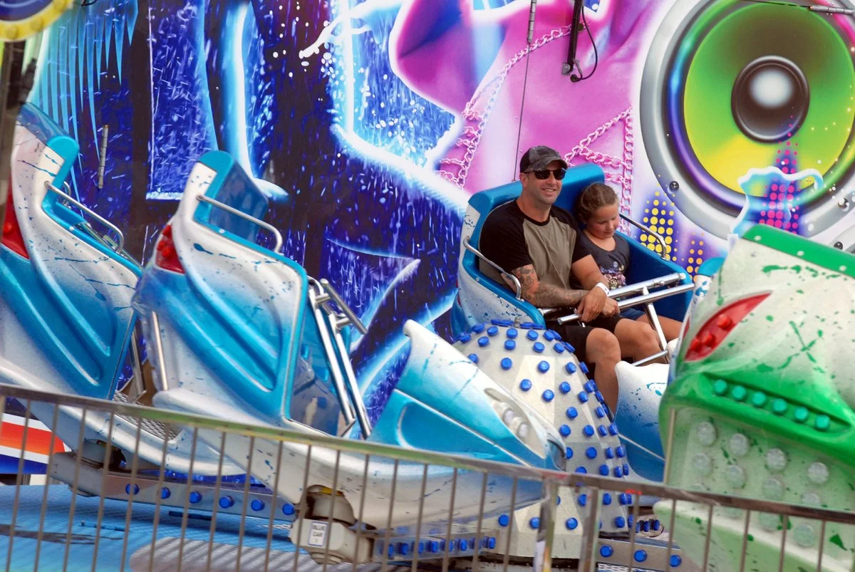 A man and a boy on one of the Sunshine Fair's midway rides.